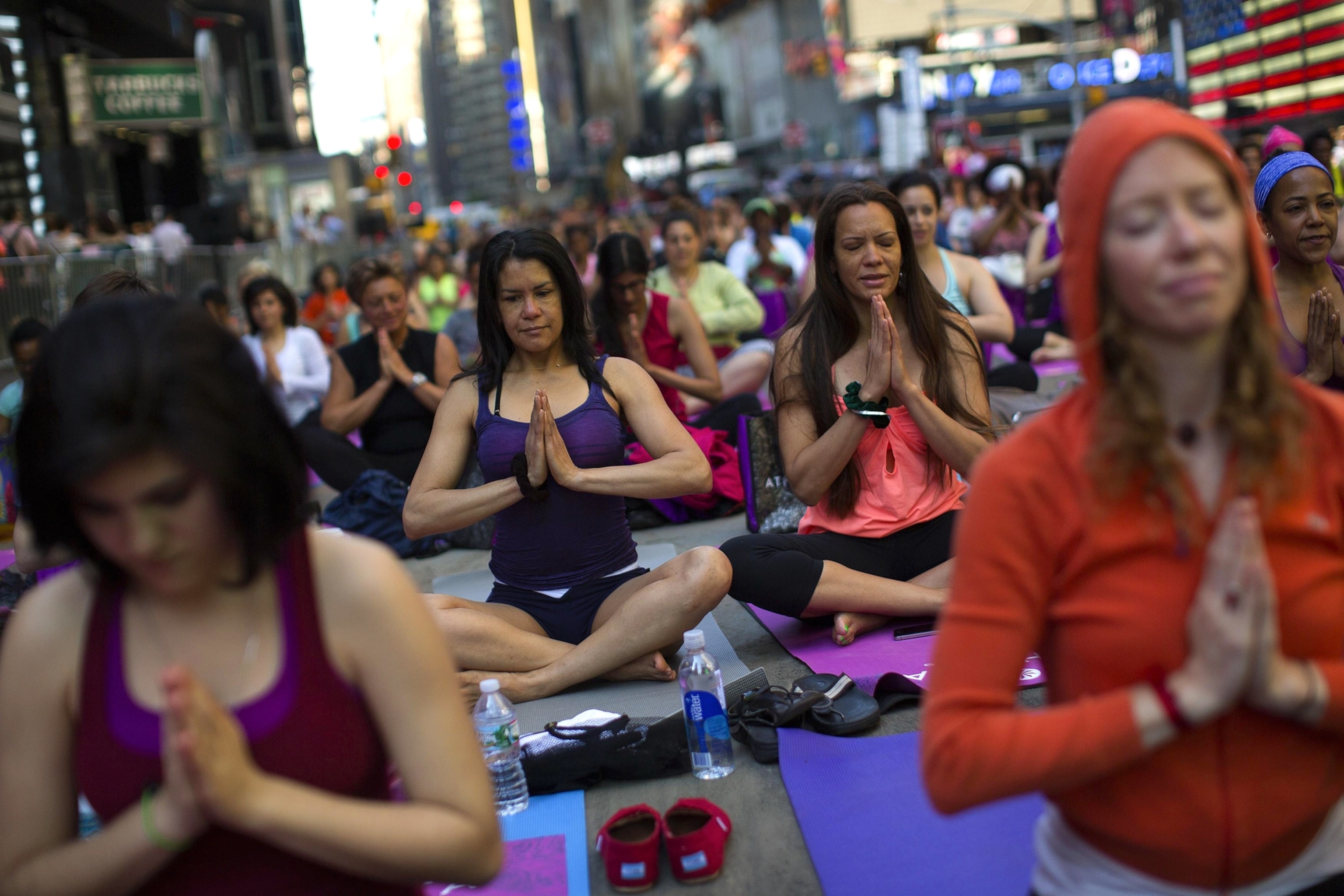 people practicing yoga in Times Square on the morning of the summer solstice