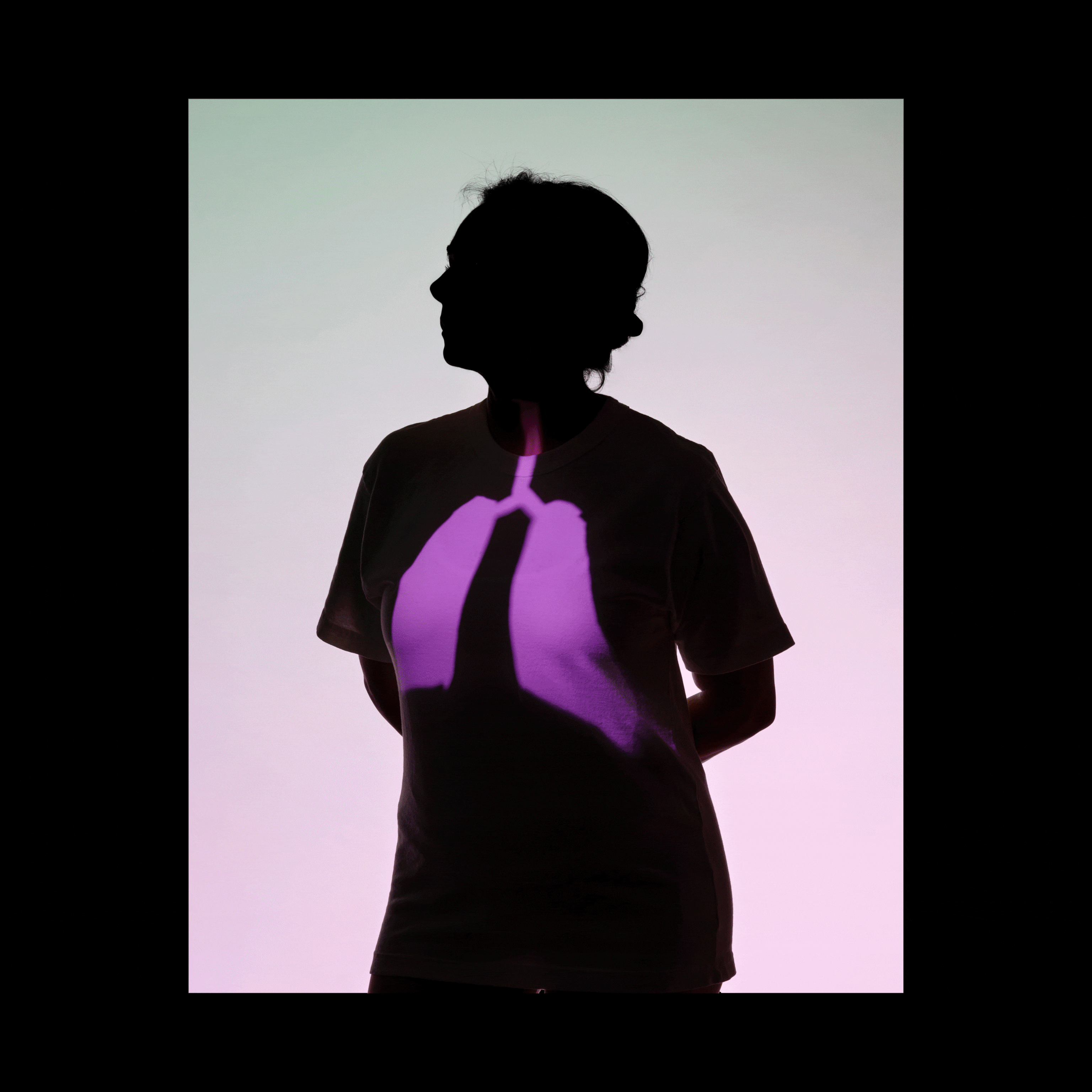 A woman silhouetted against a background that fade from light green to light pink; projections of intestines, breasts, and lungs cycle every second, appearing on the silhouetted woman's body