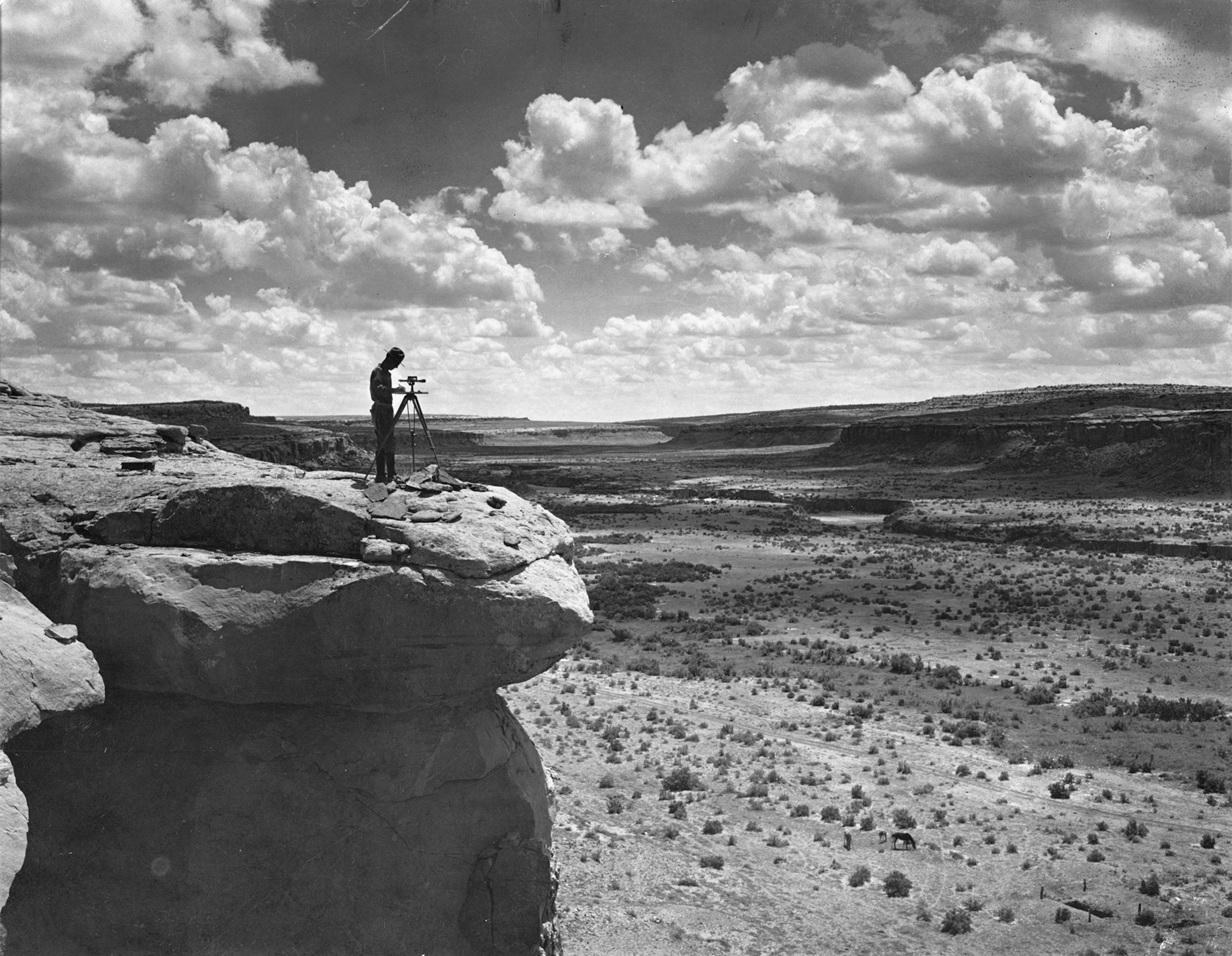 a surveyor maps Chaco Canyon while standing on a cliff.