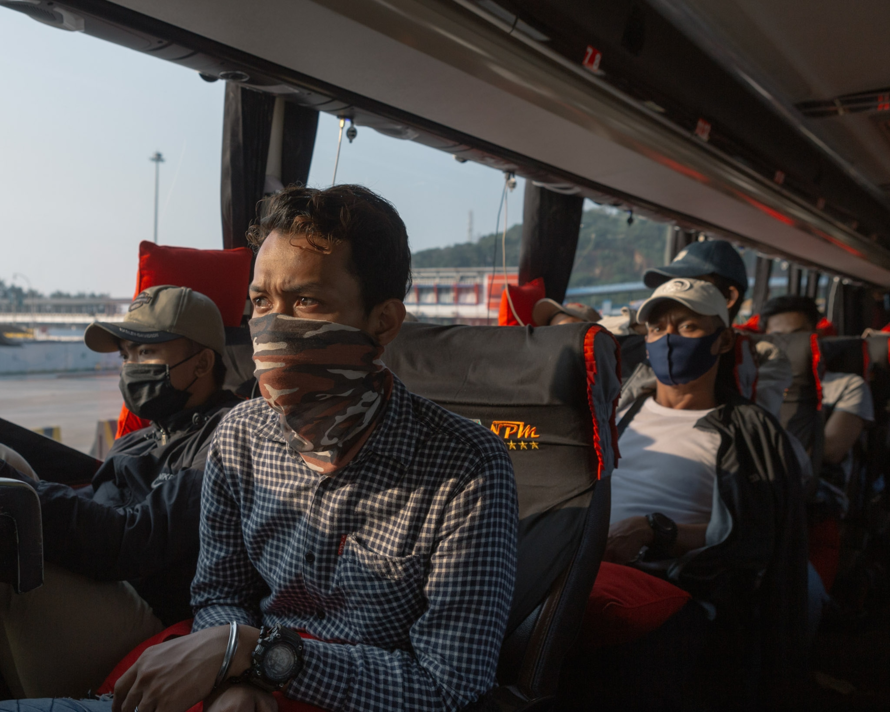 men wearing face masks on a minibus