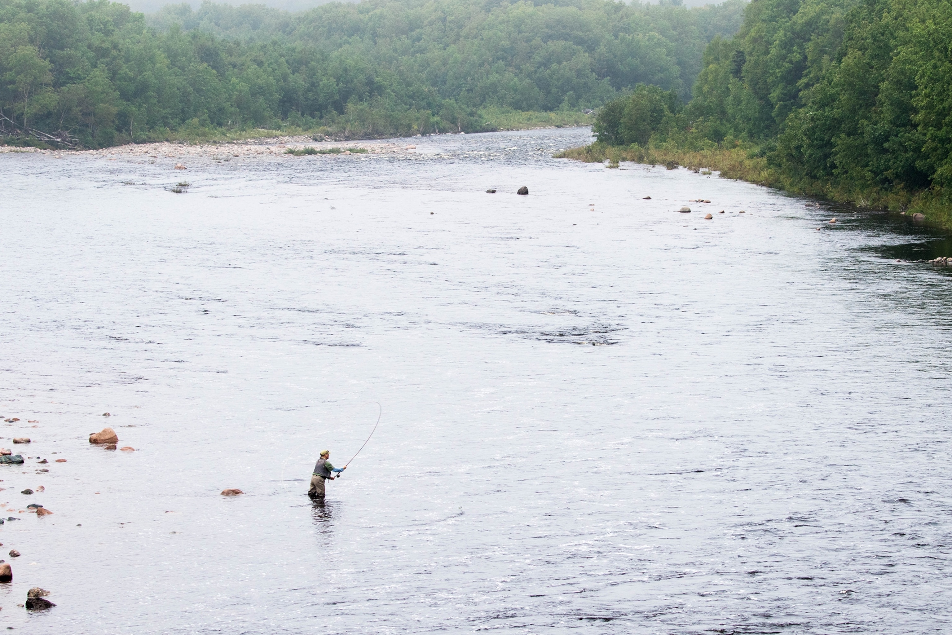a fly-fisherman on Chéticamp River in Nova Scotia, Canada