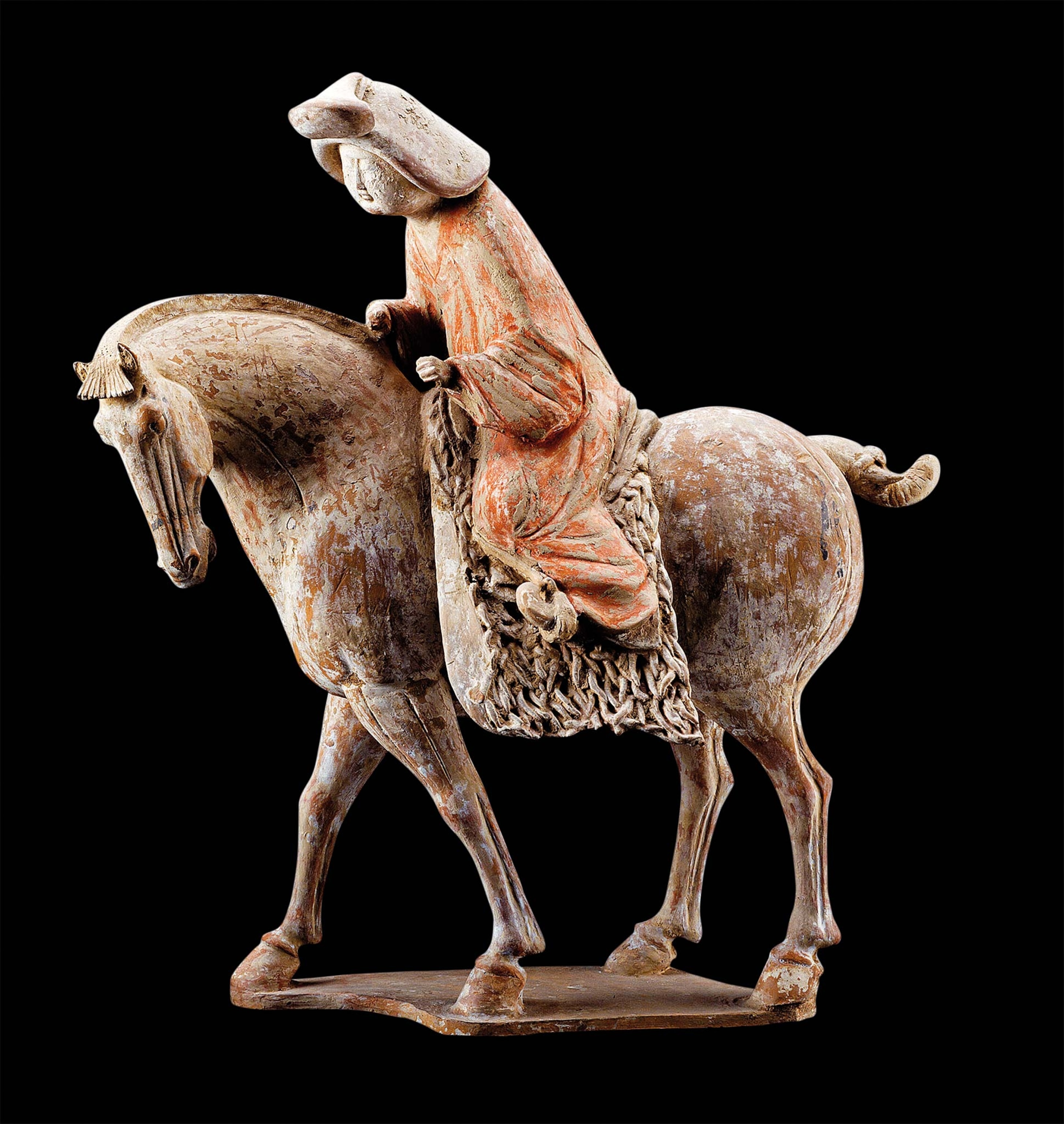 A figurine of a rider using saddle blankets and stirrups on a horse from the Tang dynasty