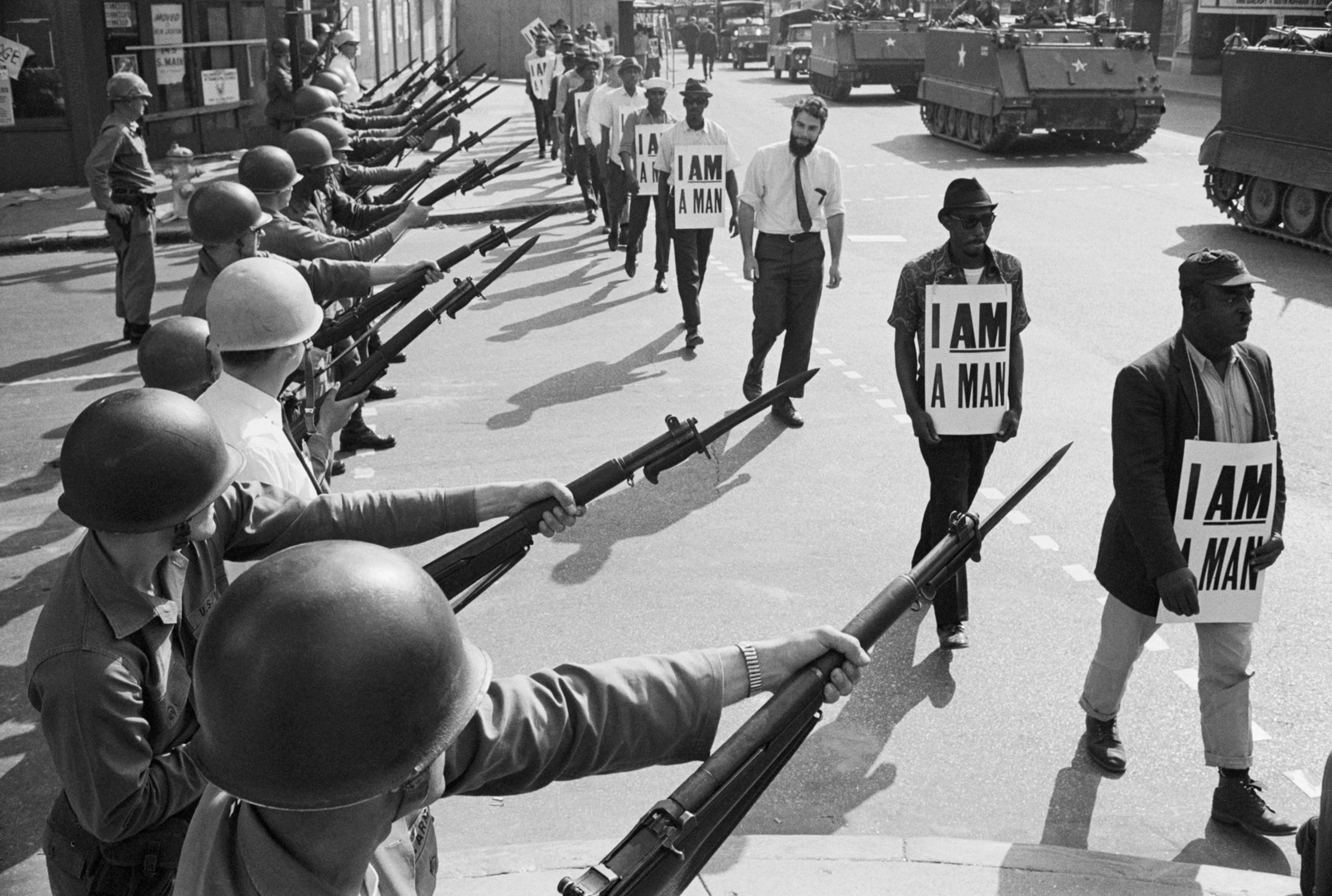 U.S. National Guard troops block off Beale Street as Civil Rights marchers wearing placards reading, "I AM A MAN" pass by on March 29, 1968.