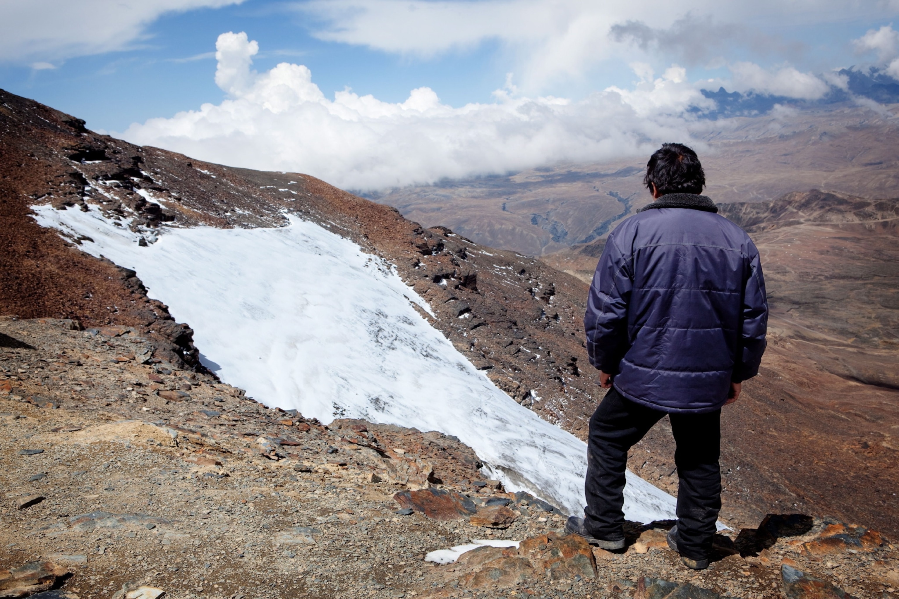 Man looks at small glacier patch