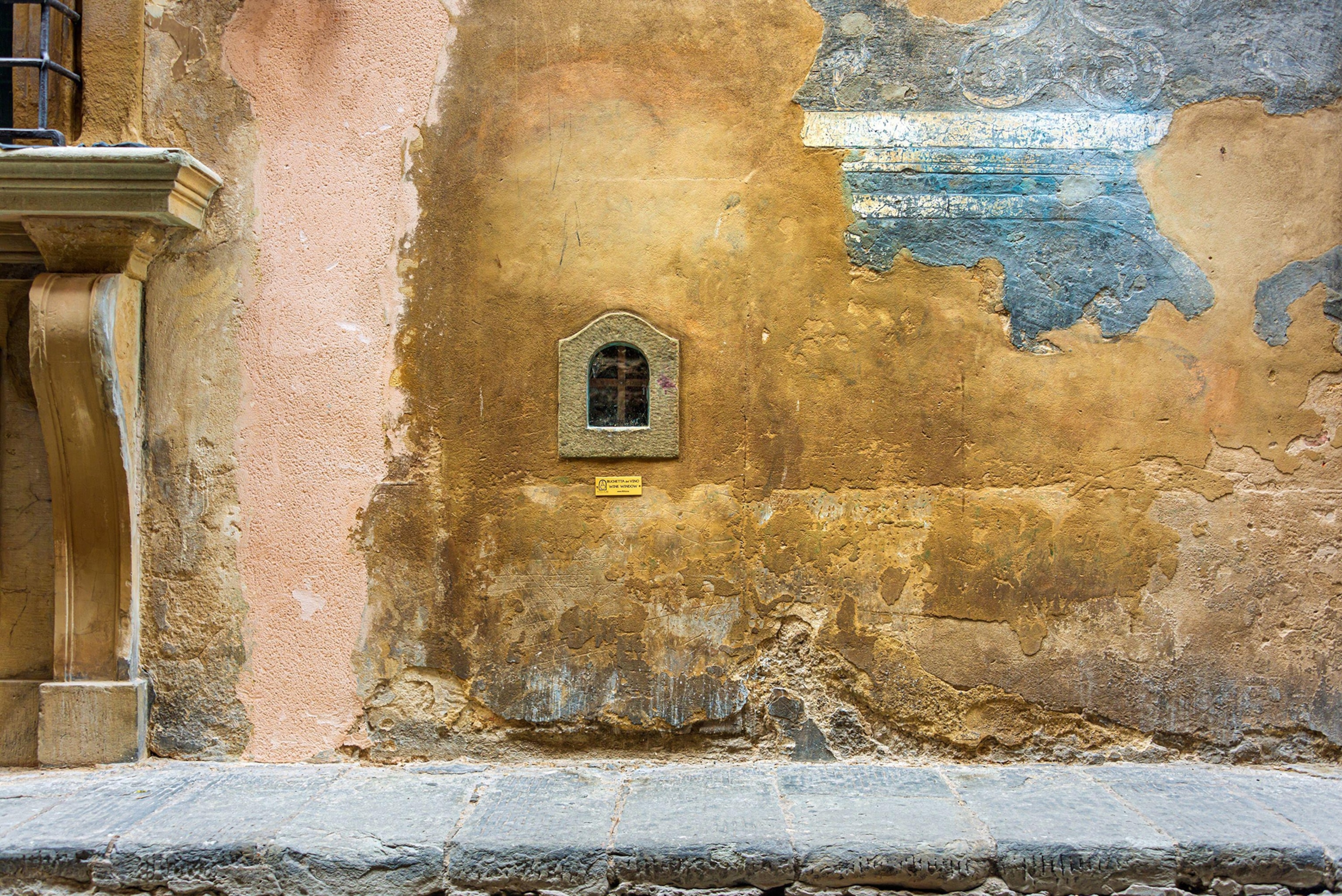 a typical wine window -buchetta del vino - located in the facade of a palace of Borgo degli Albizi - Florence, Italy