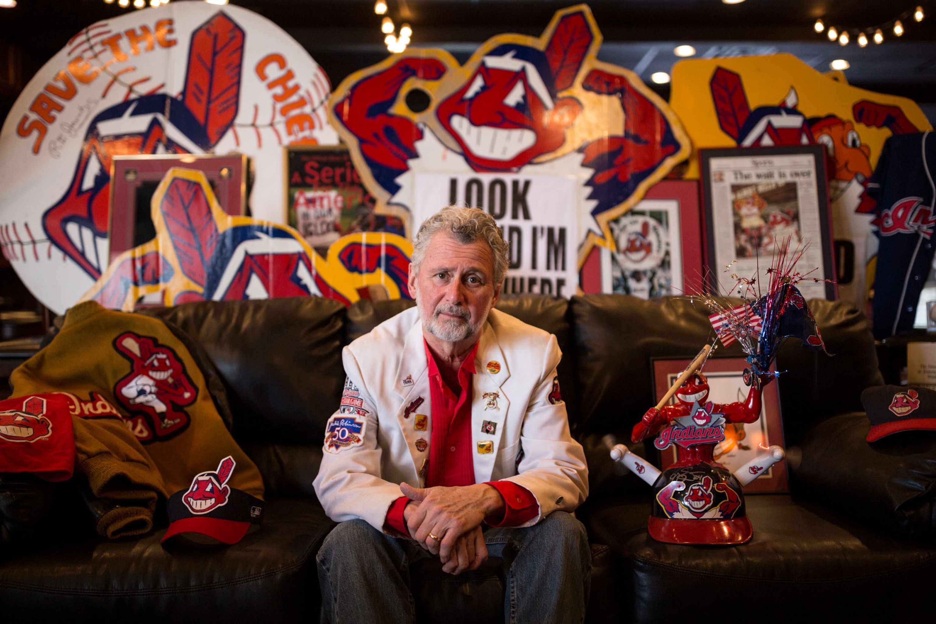 a man posing for a portrait surrounded by sports memorabilia