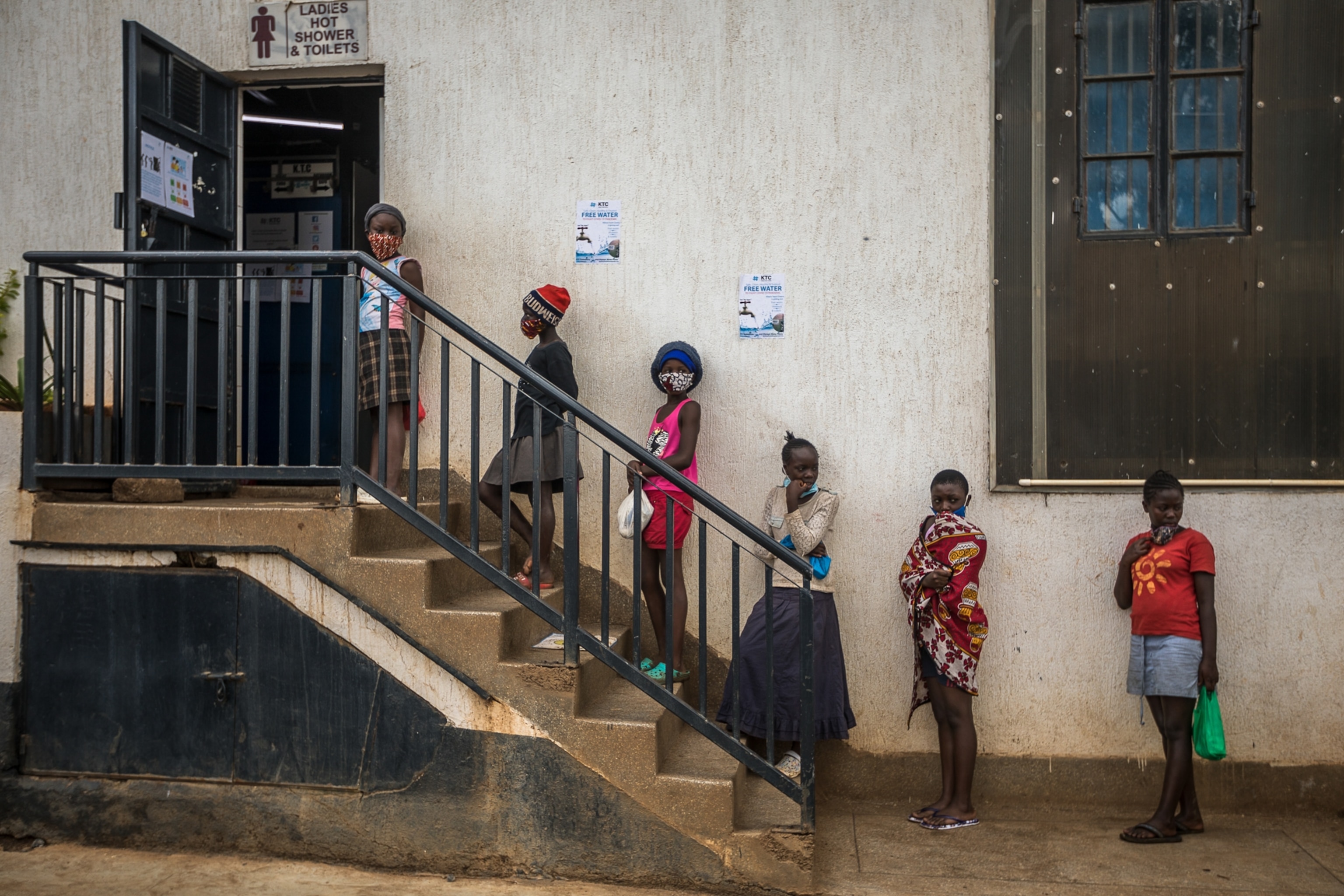 girls stand in line maintaining social distance in Kenya