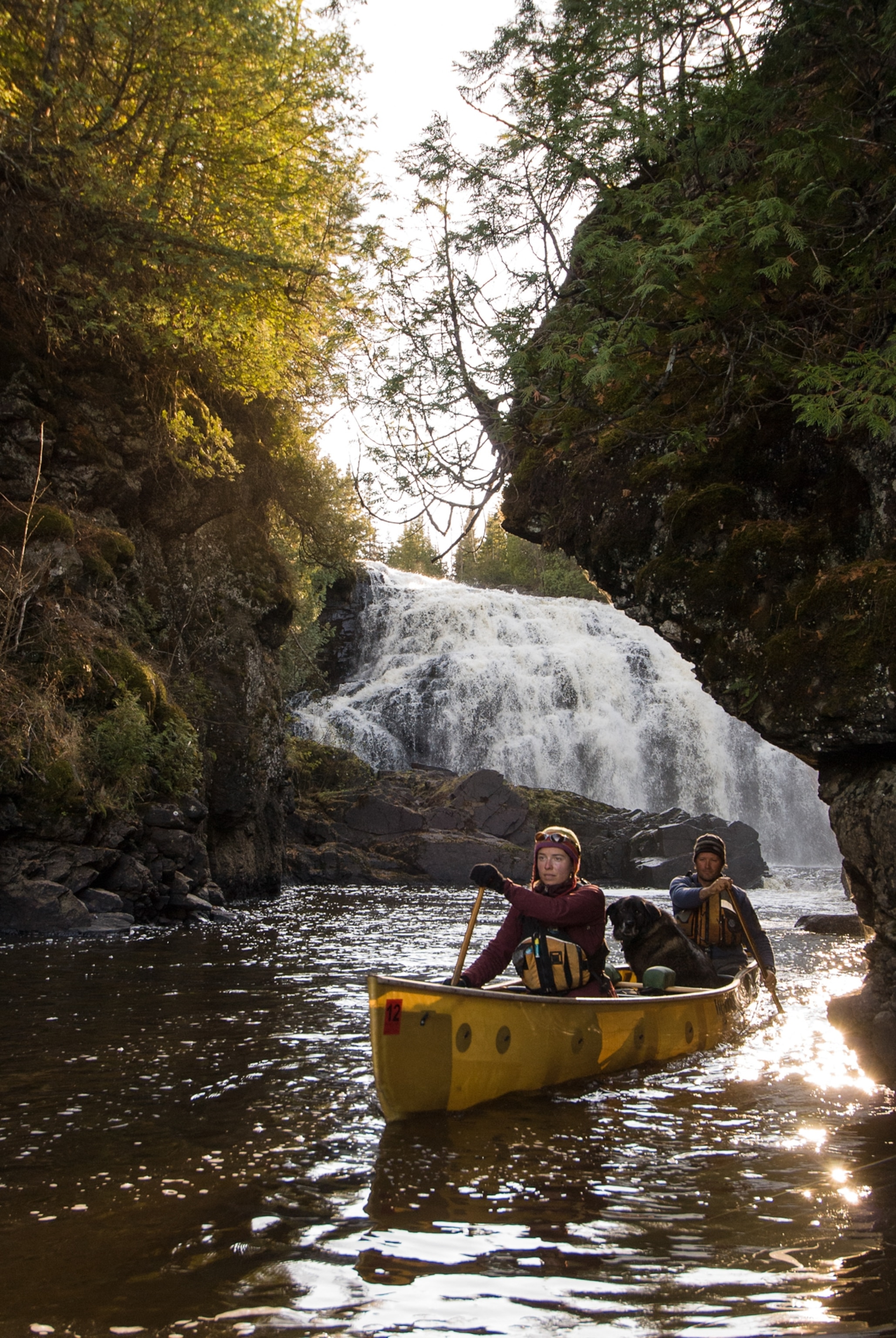 Man and woman paddling away from Partridge Falls on the Pigeon River
