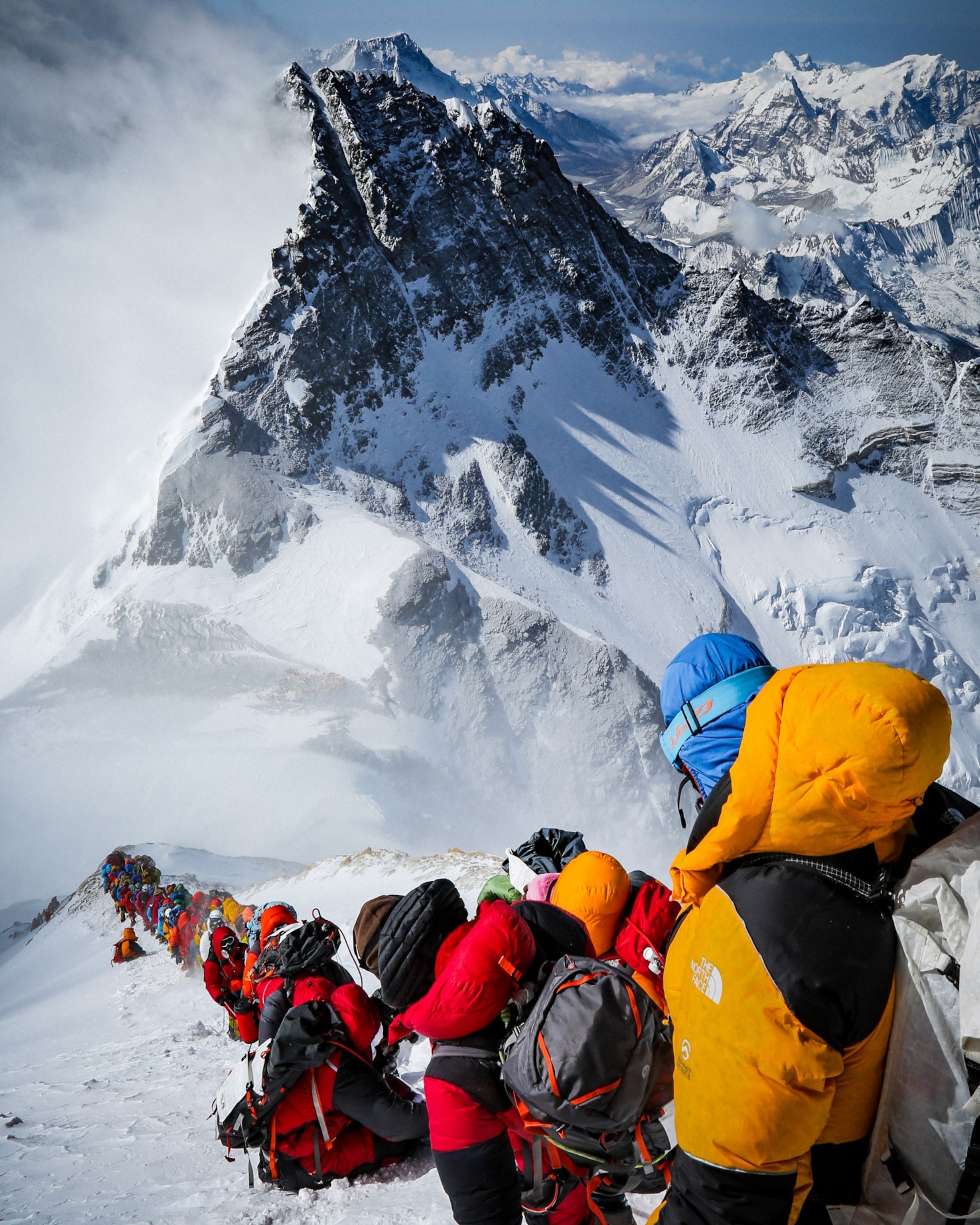 crowds of people ascending to the summit of Mount Everest