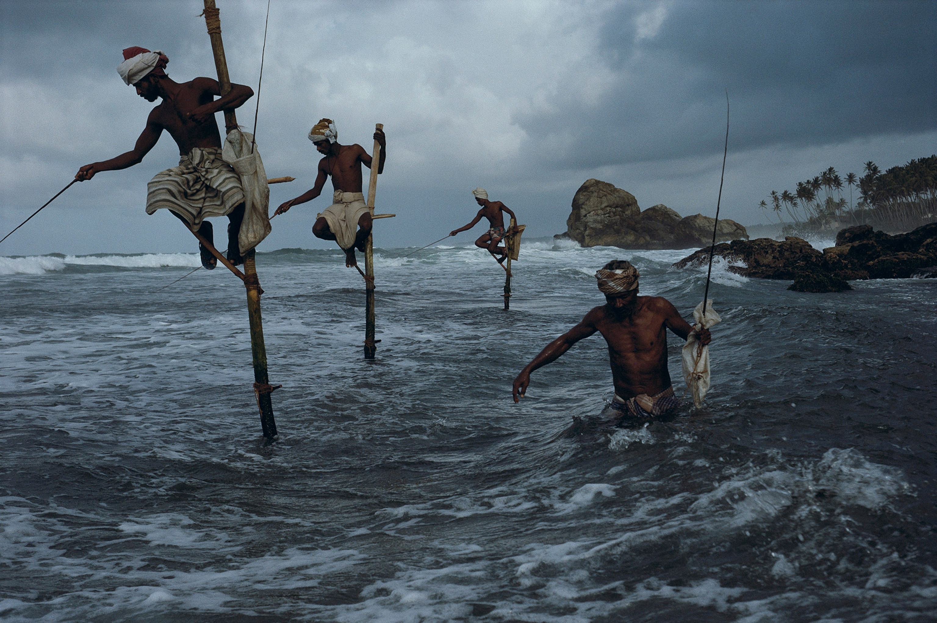men fishing on stilts