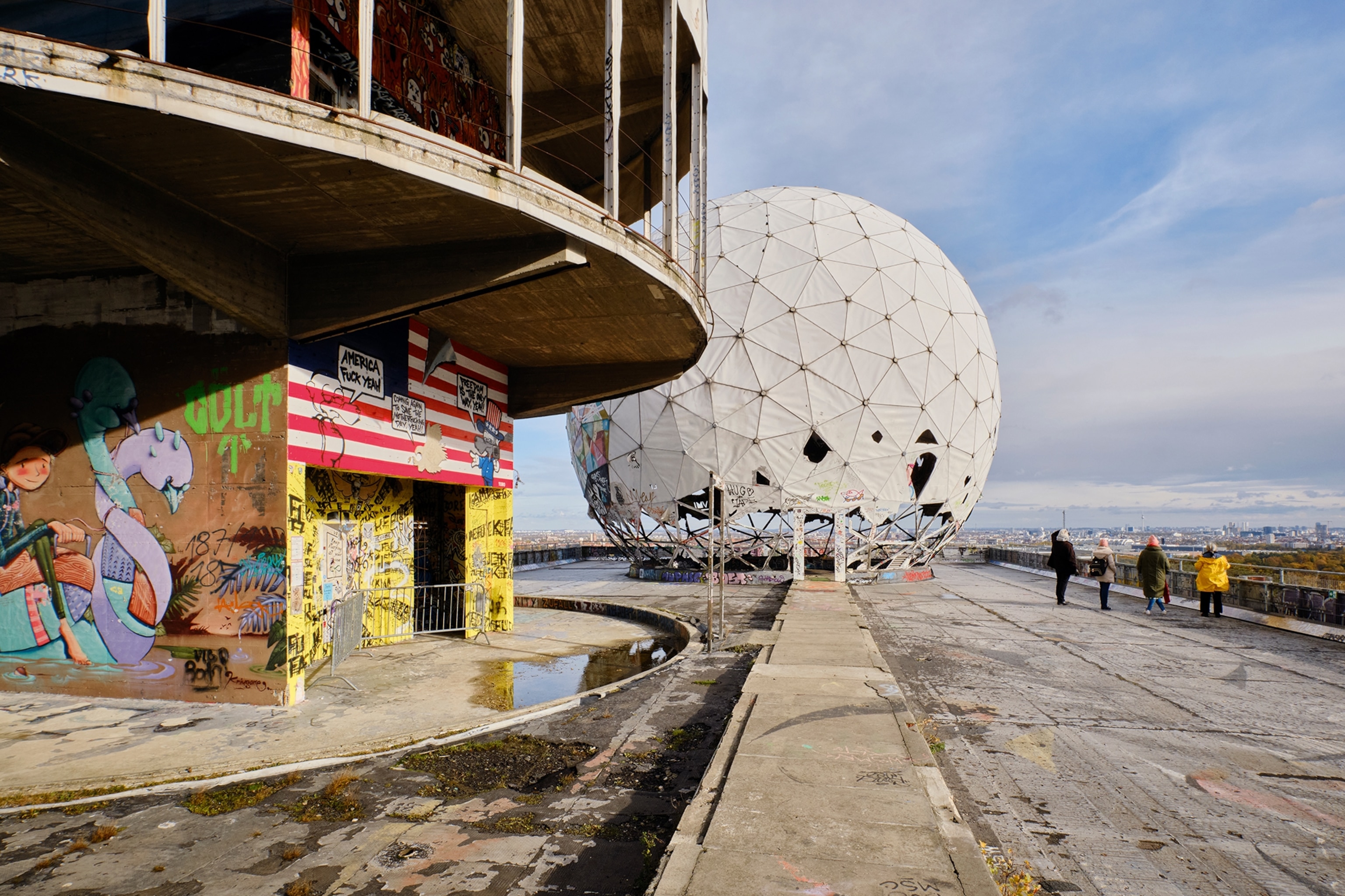 A building with graffiti art and a white spherical structure in the background.
