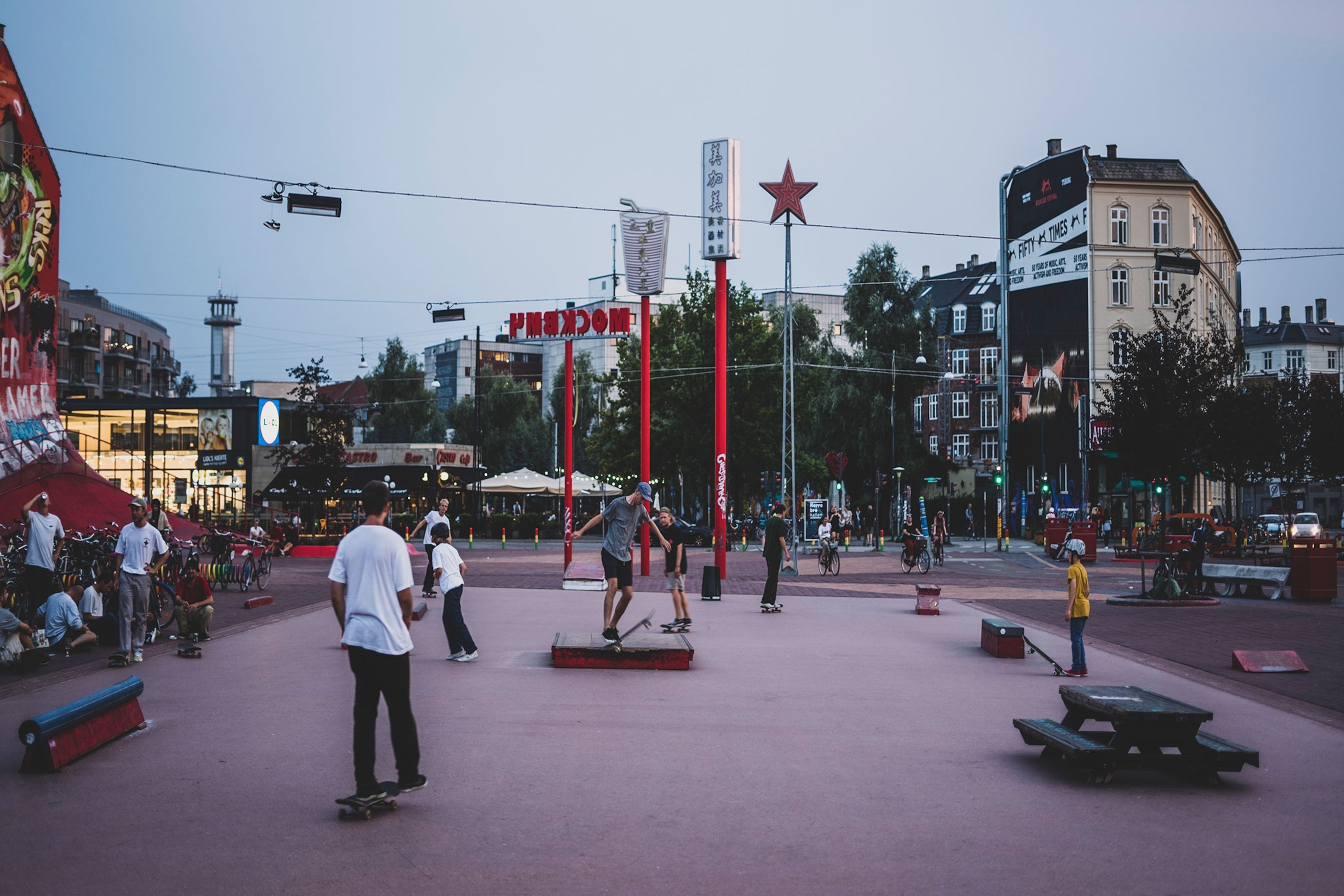 Skateboarders do tricks in an urban park in Copenhagen.