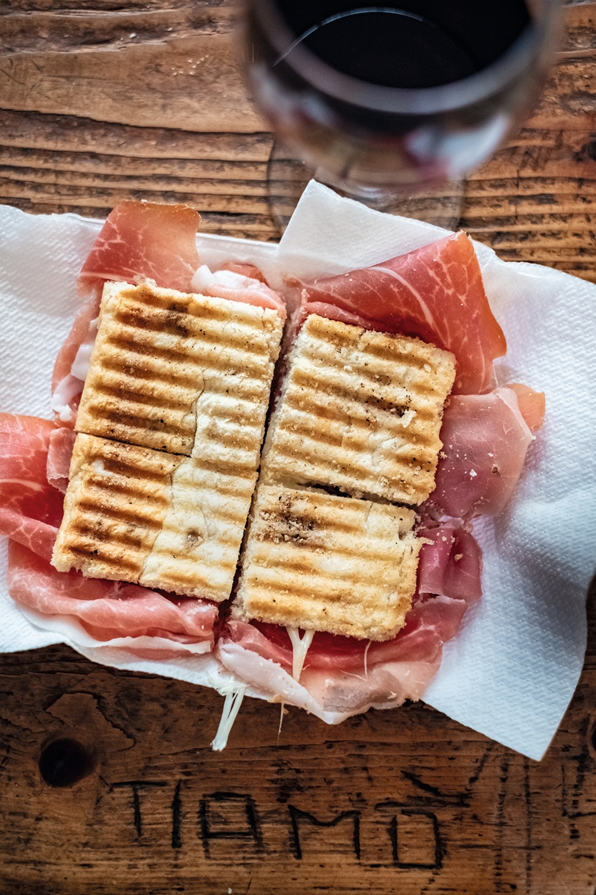 The 'Principe' toasted focaccia with prosciutto crudo and melted Parmesan, served with a local red wine at Enoteca Fontana.