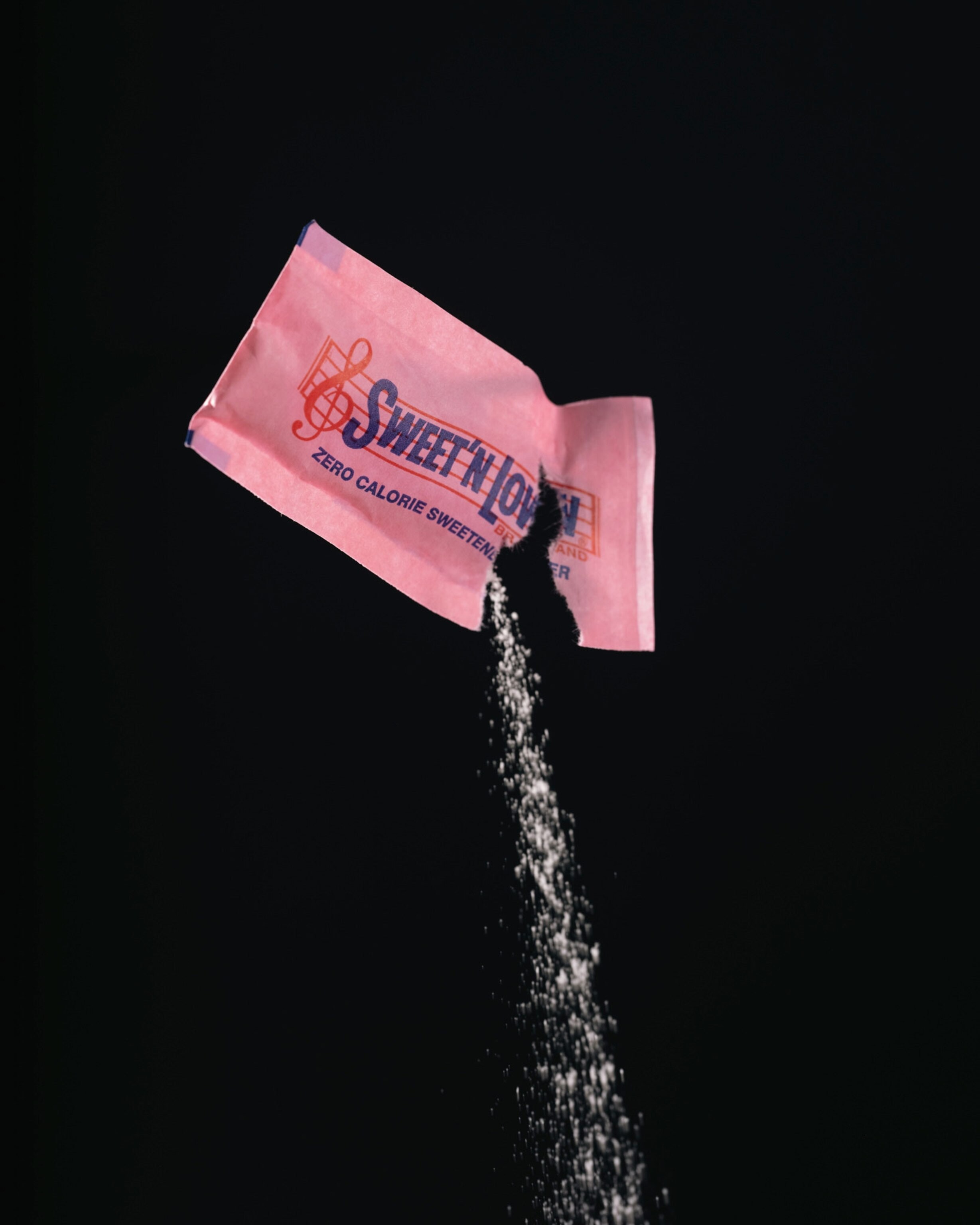 Studio shoot with black backdrop showing packets of artificial sweeteners