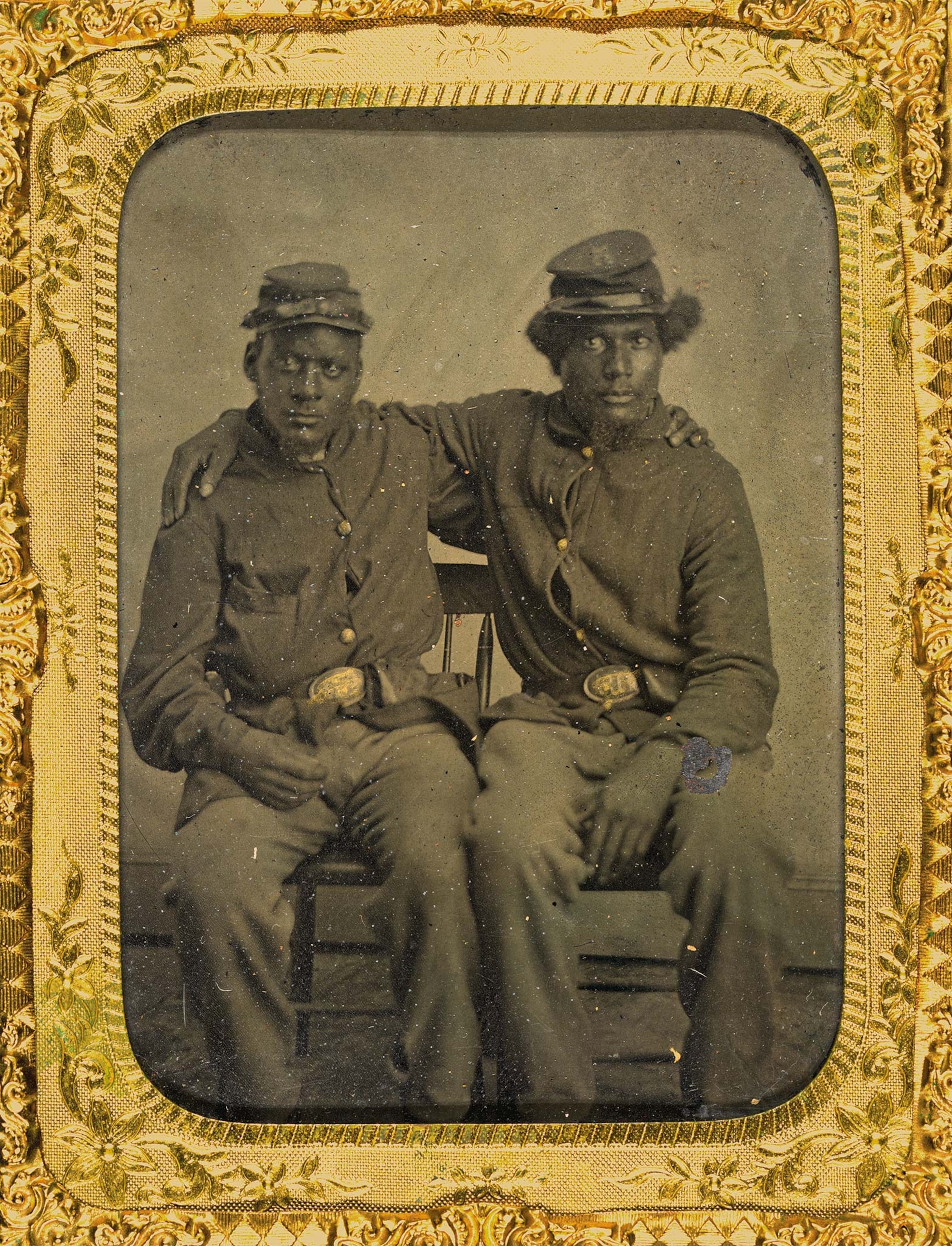 Two Union soldiers, possibly identified as brothers Baldy Guy (at left) and George Guy, sit together in a picture surrounded by a gold frame