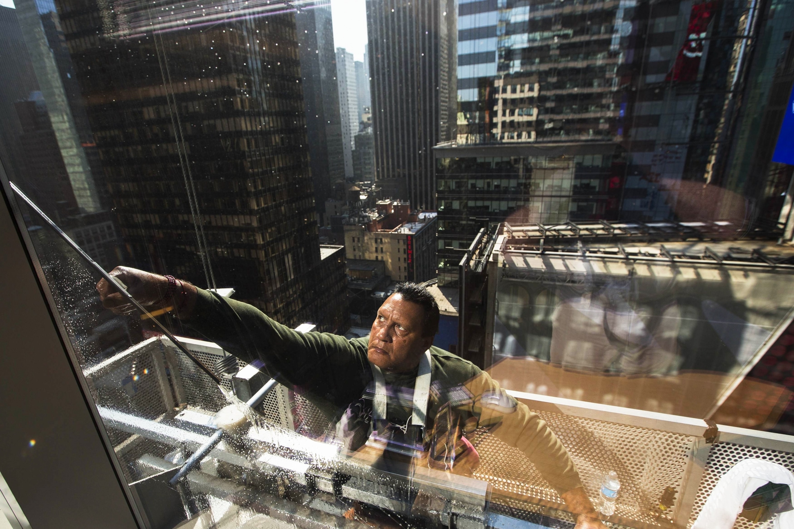 a window washer at work cleaning a building in Times Square in New York City
