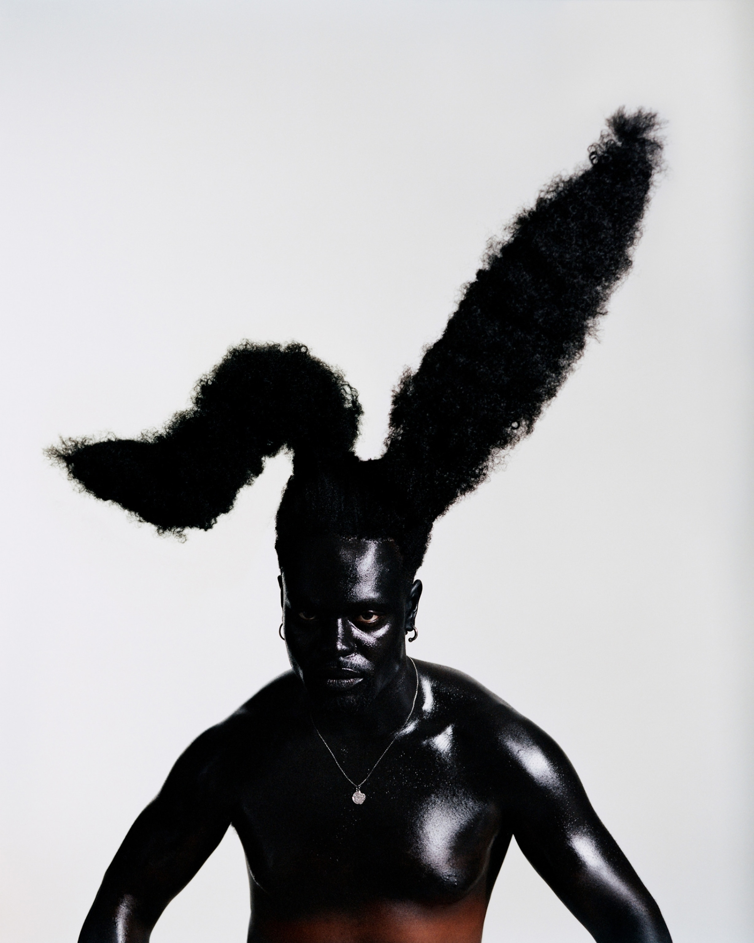 Portrait of a painted black man with long rabbit ears.