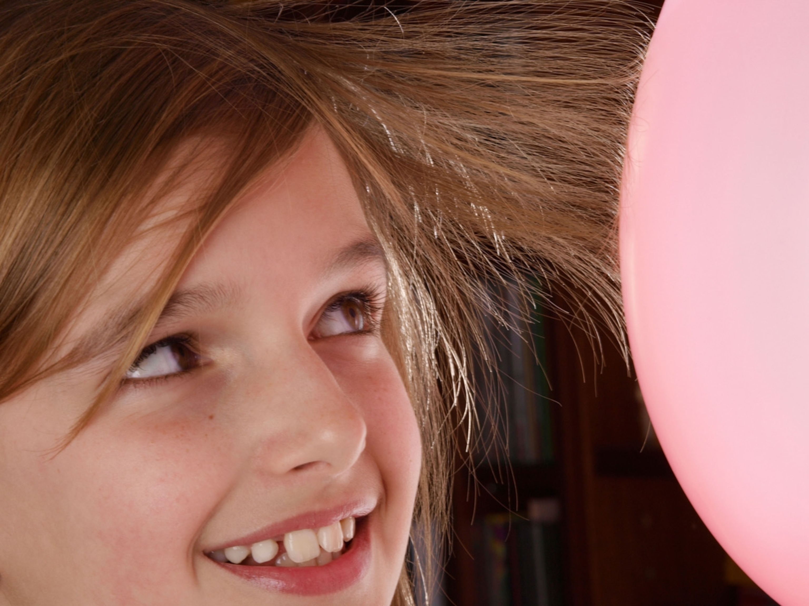 Young girl teenager with balloon and very static hair physics experiment. Netherlands