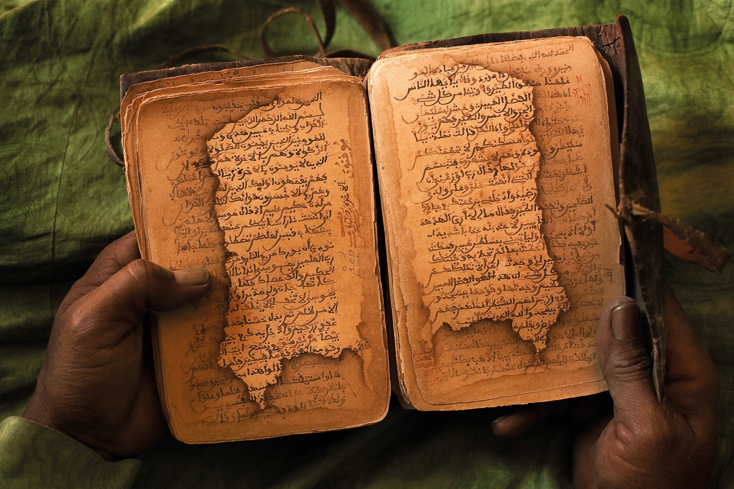 The hands of Timbuktu bibliophile Ahmad Bul Araf cradle the pages of a 16th-century Muslim text.