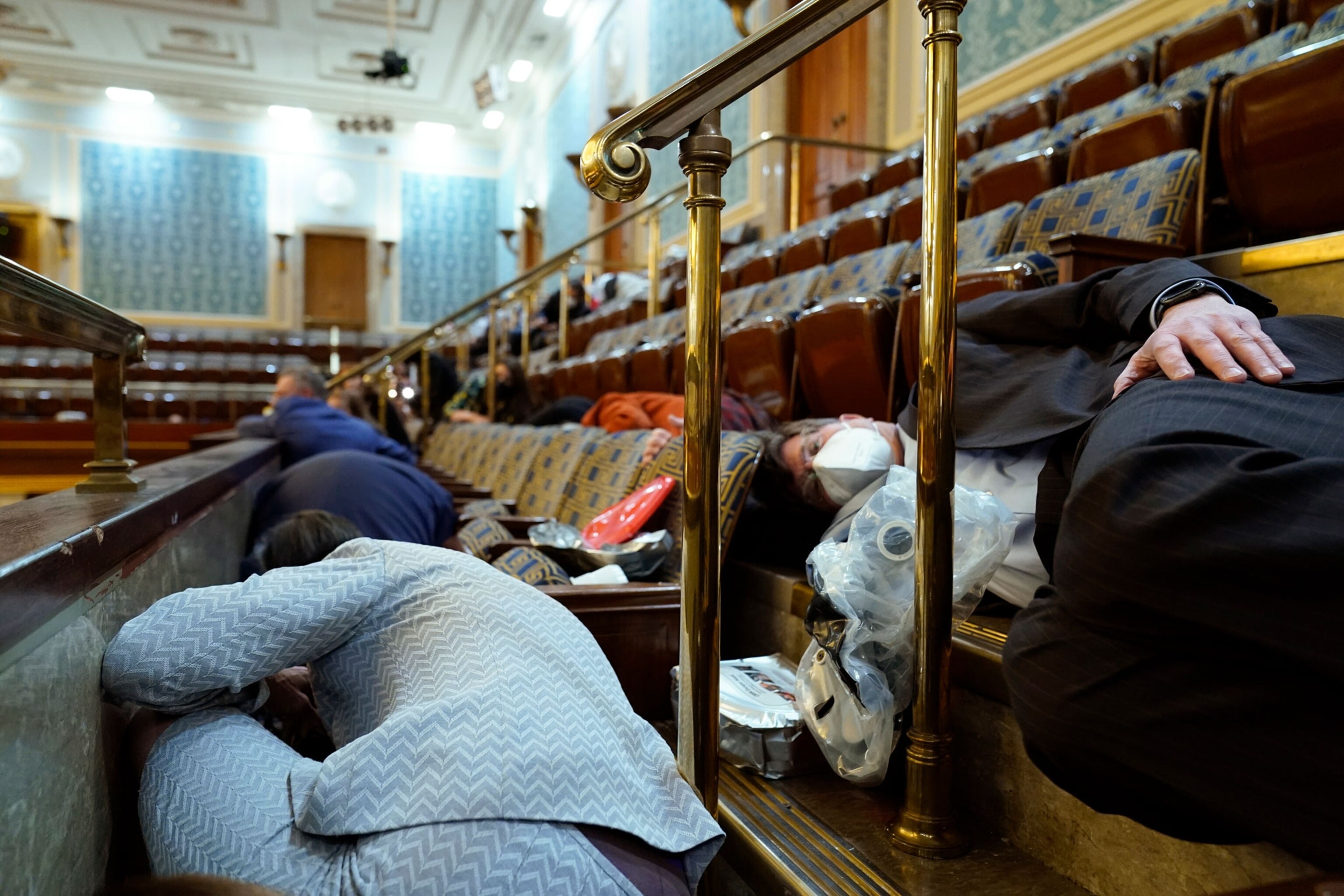 People hide among seating and railing