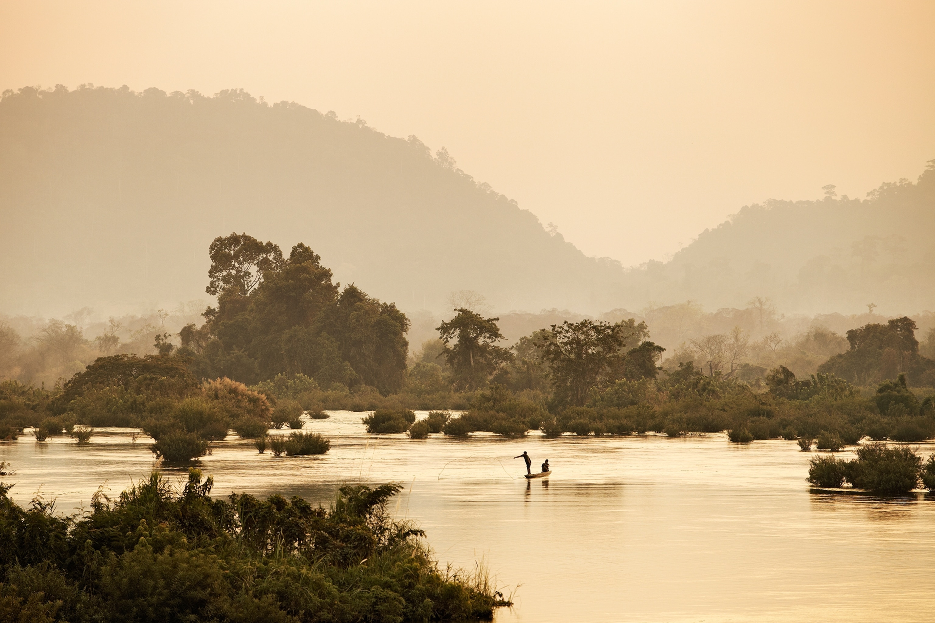 Fishermen casting nets from canoes.