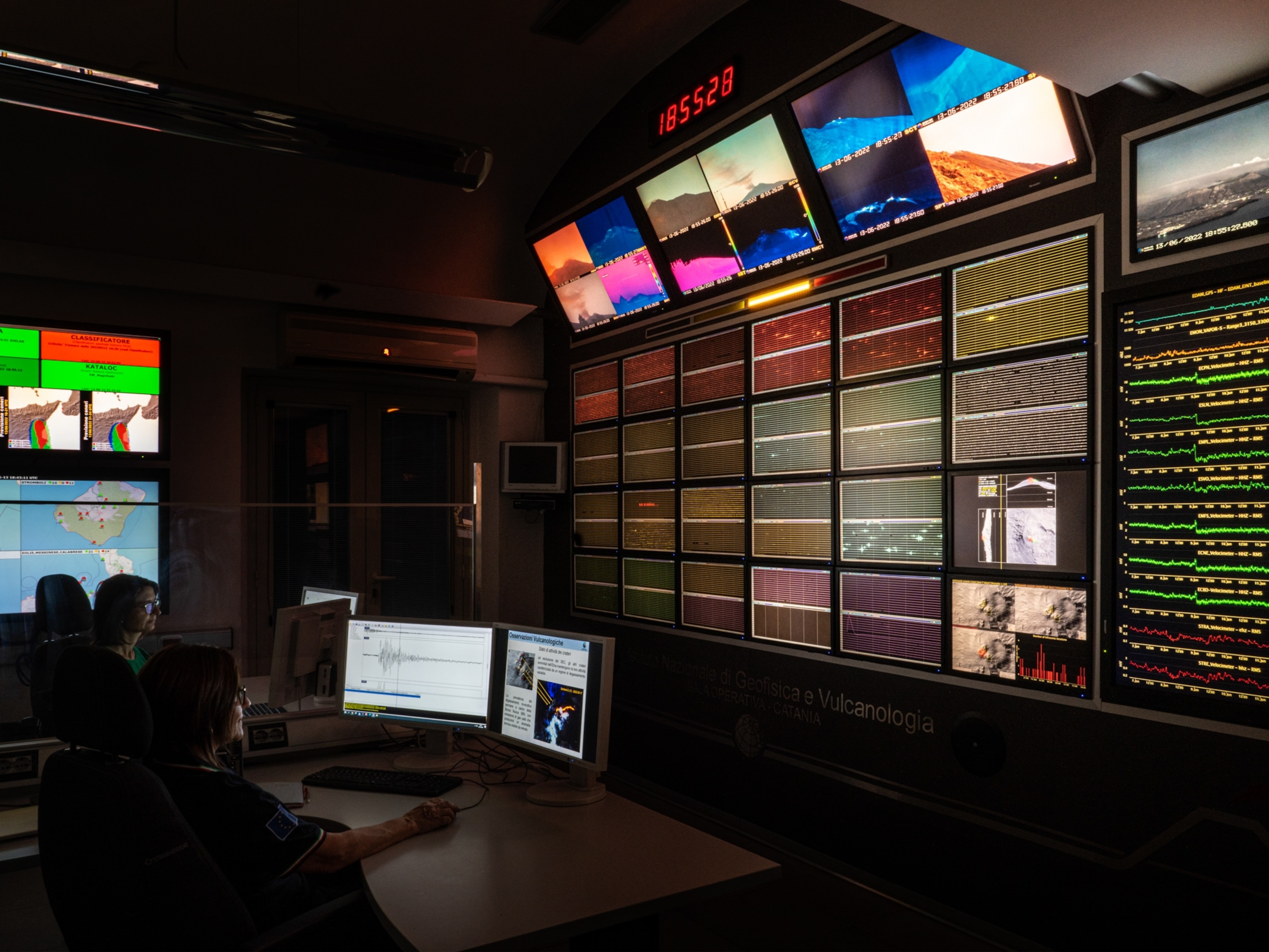 Monitoring panels of seismic waves cover the wall of a monitoring room for seismic activity.