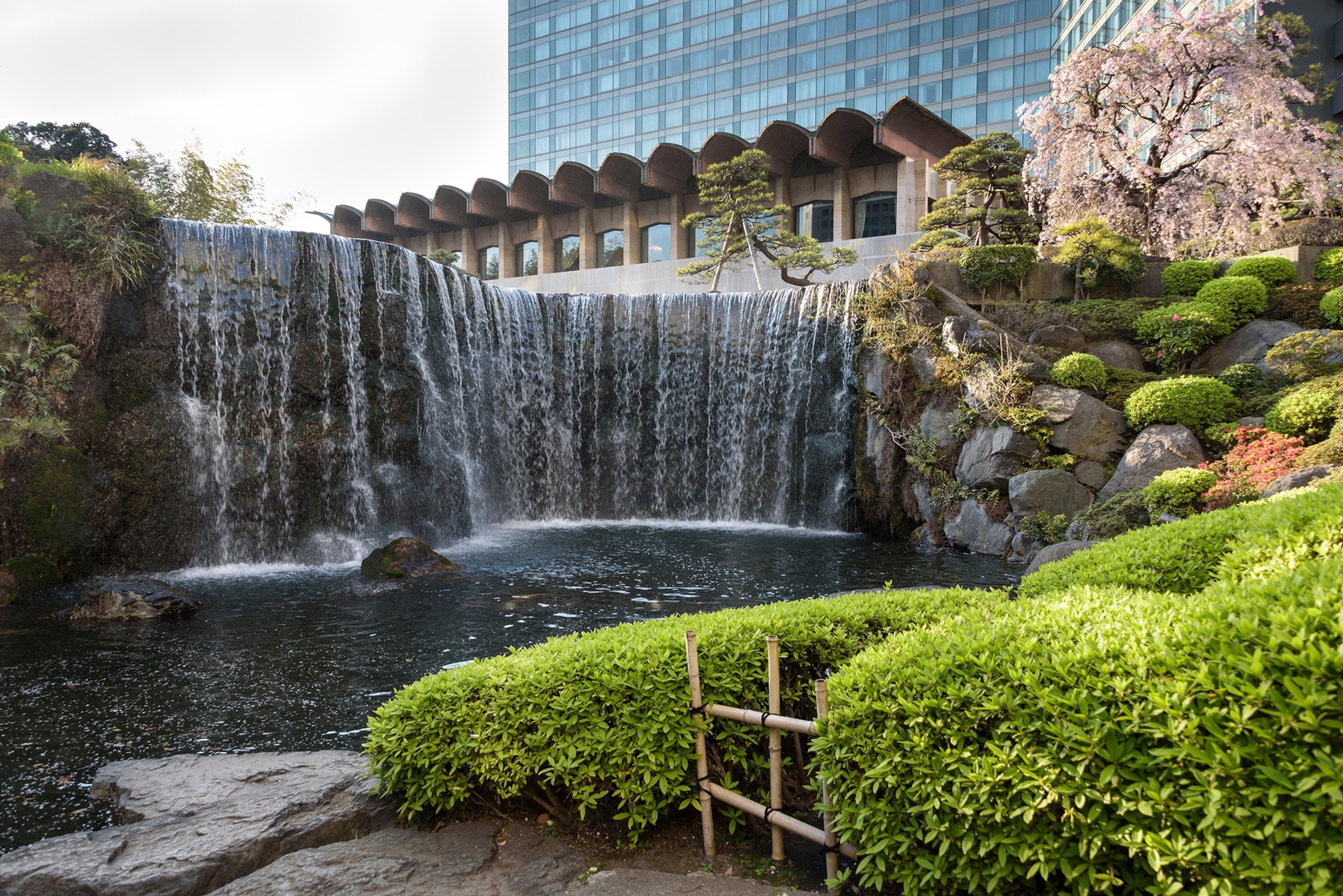 A waterfall with a garden in the front.