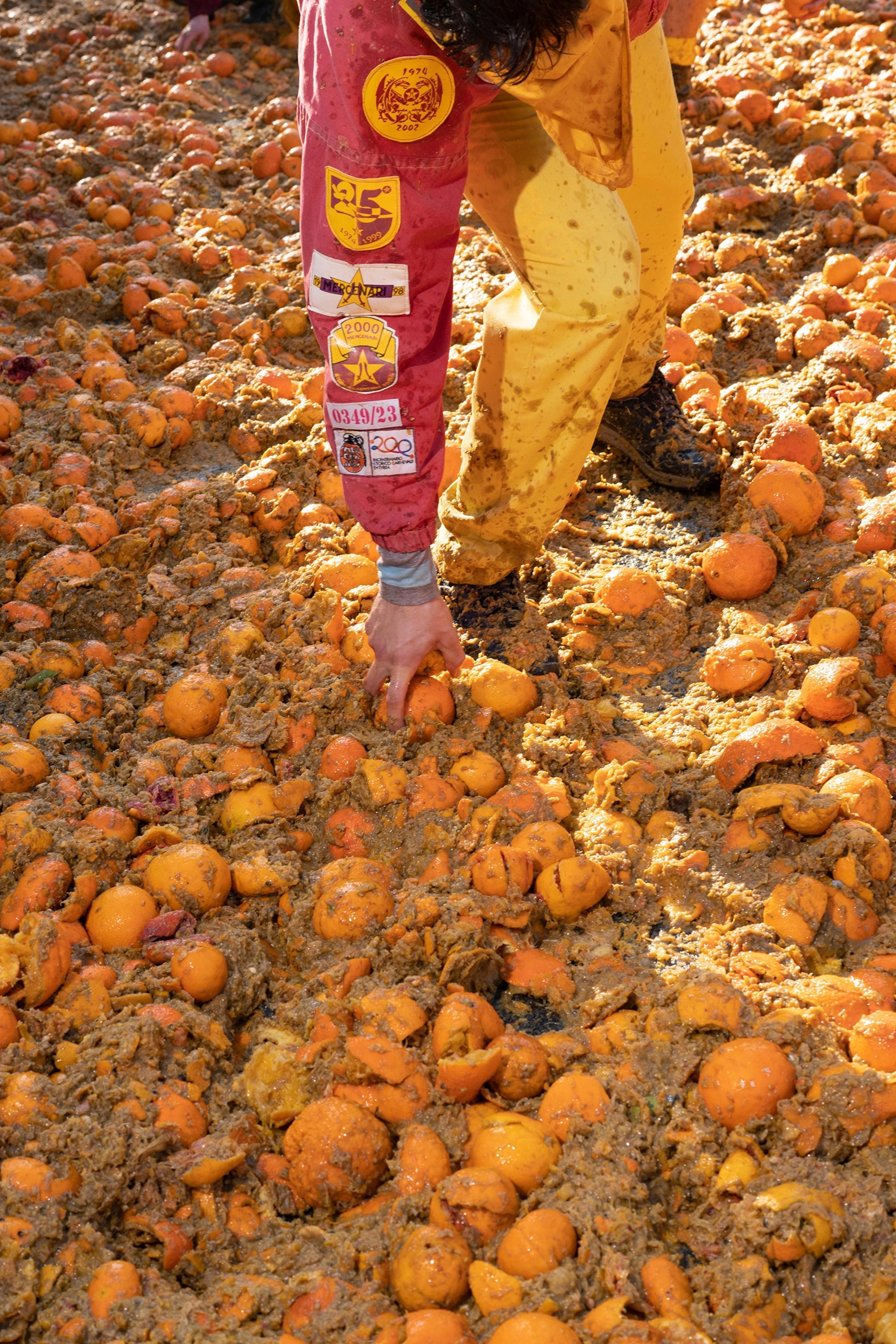 Oranges on the ground, and oranges ready to be thrown, cover the entire Piazza del Rondolino, one of the city's "battlefields." There are nine orange-thrower teams on foot and every team has a designated area for their throwers. Their throwers wear tunics and trousers in their team’s colours.
