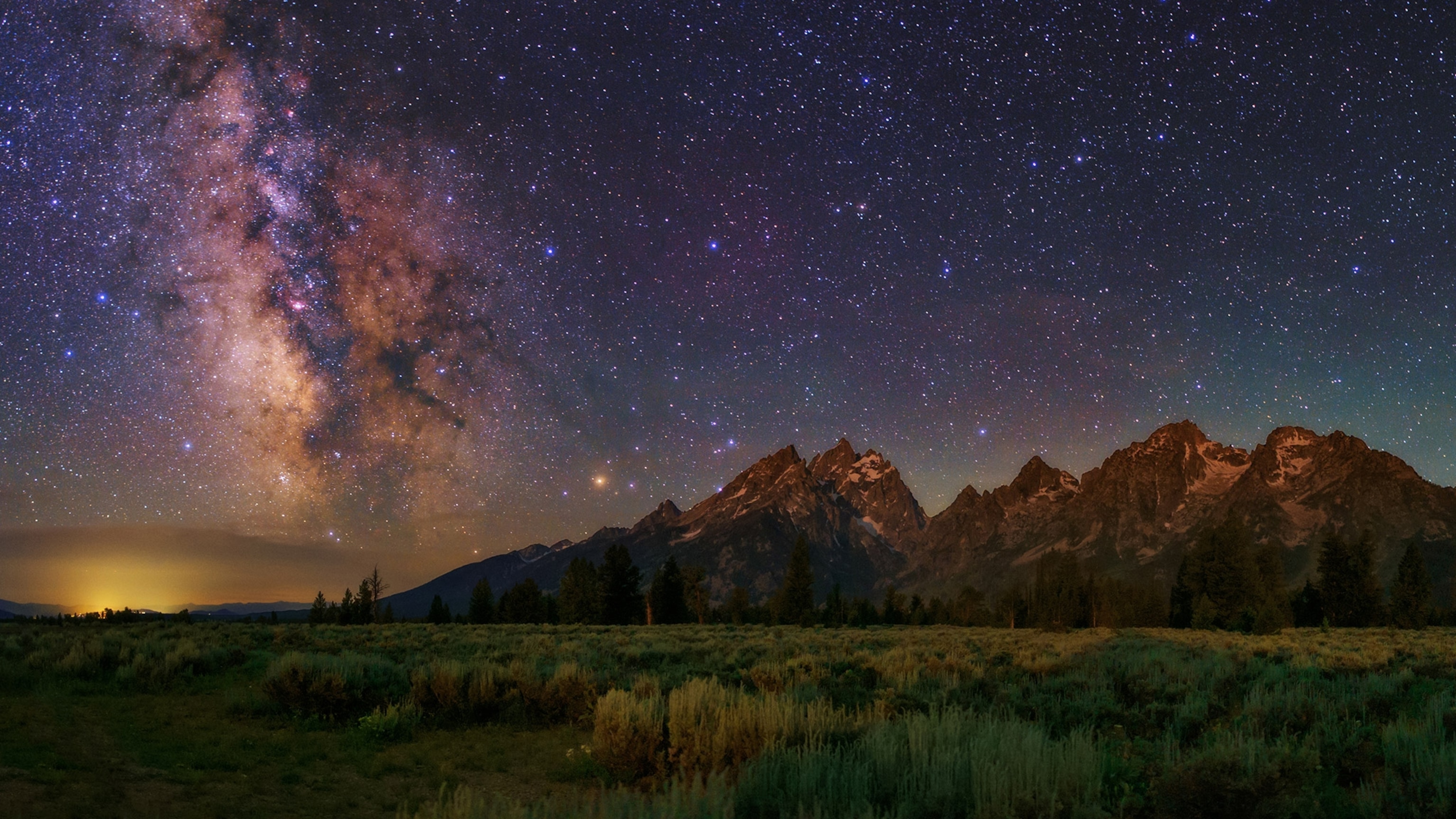 The Milky Way shines over the Grand Teton mountain range.