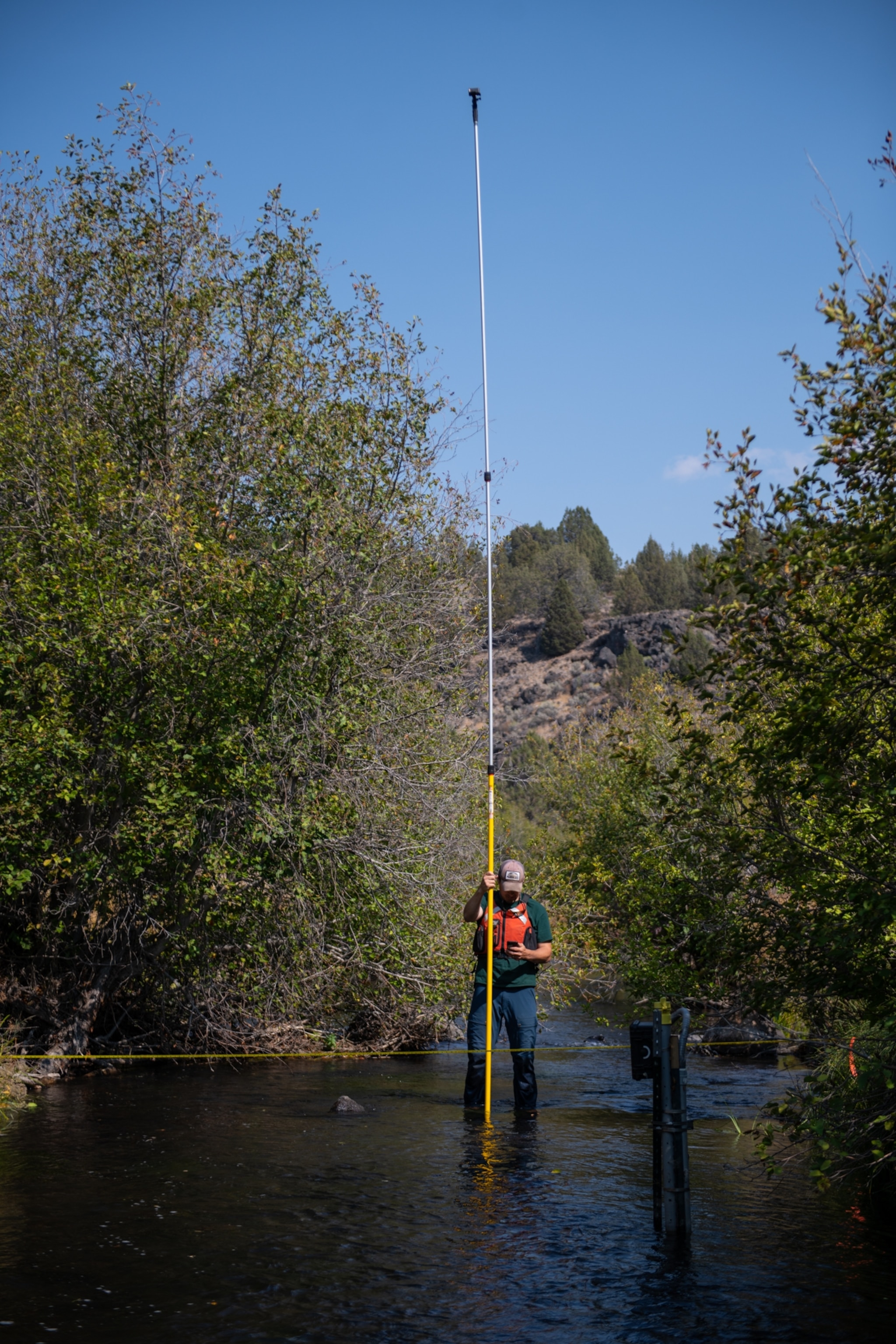 Picture of Brandon Overstreet holding a tall pole with a camera mounted on top to visualize the terrain from above.