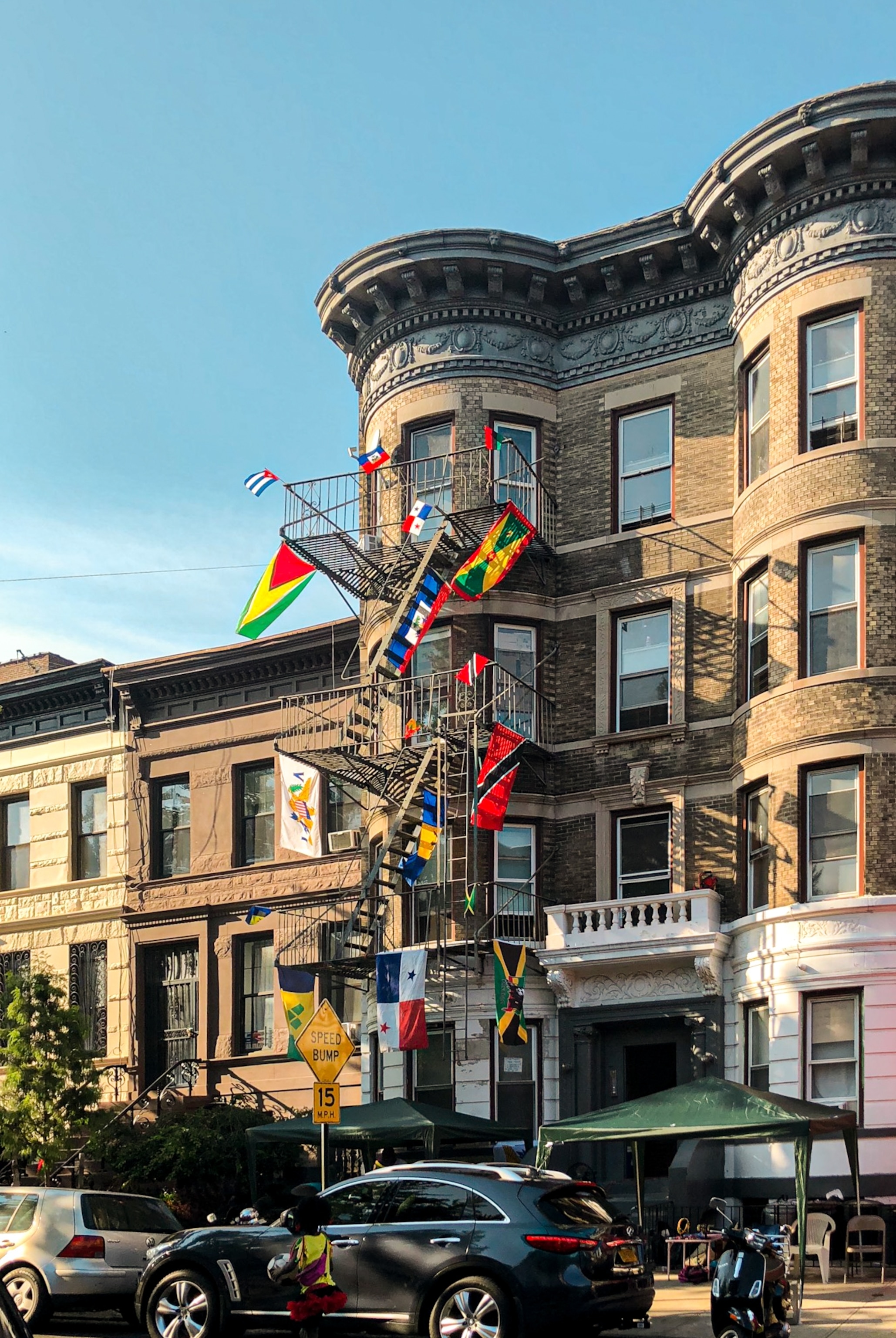 Flags representing various nations across the Caribbean hang from an apartment building in the Flatbush neighborhood of Brooklyn, NY.
