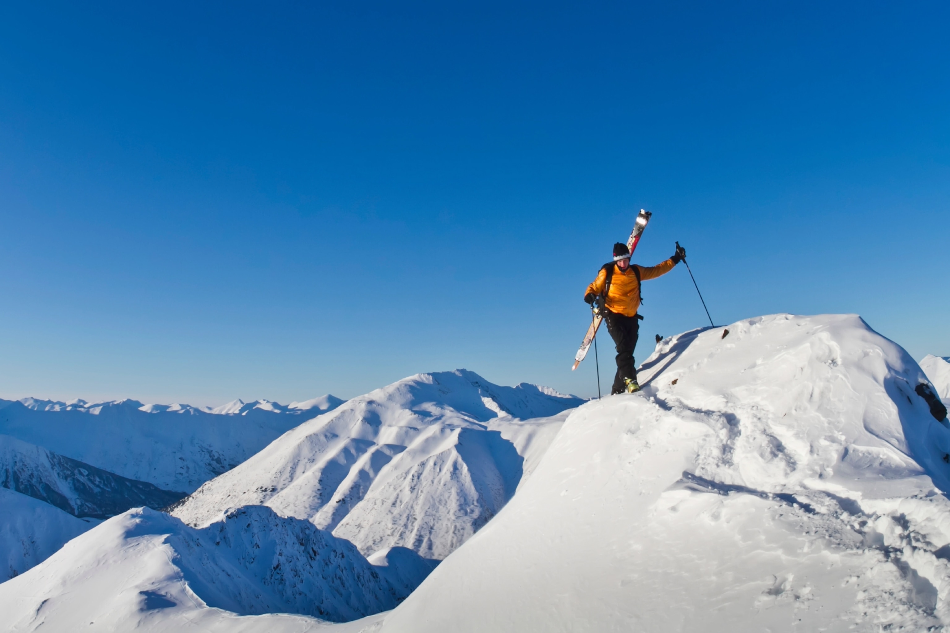 Man climbing a snow ridge for back country skiing