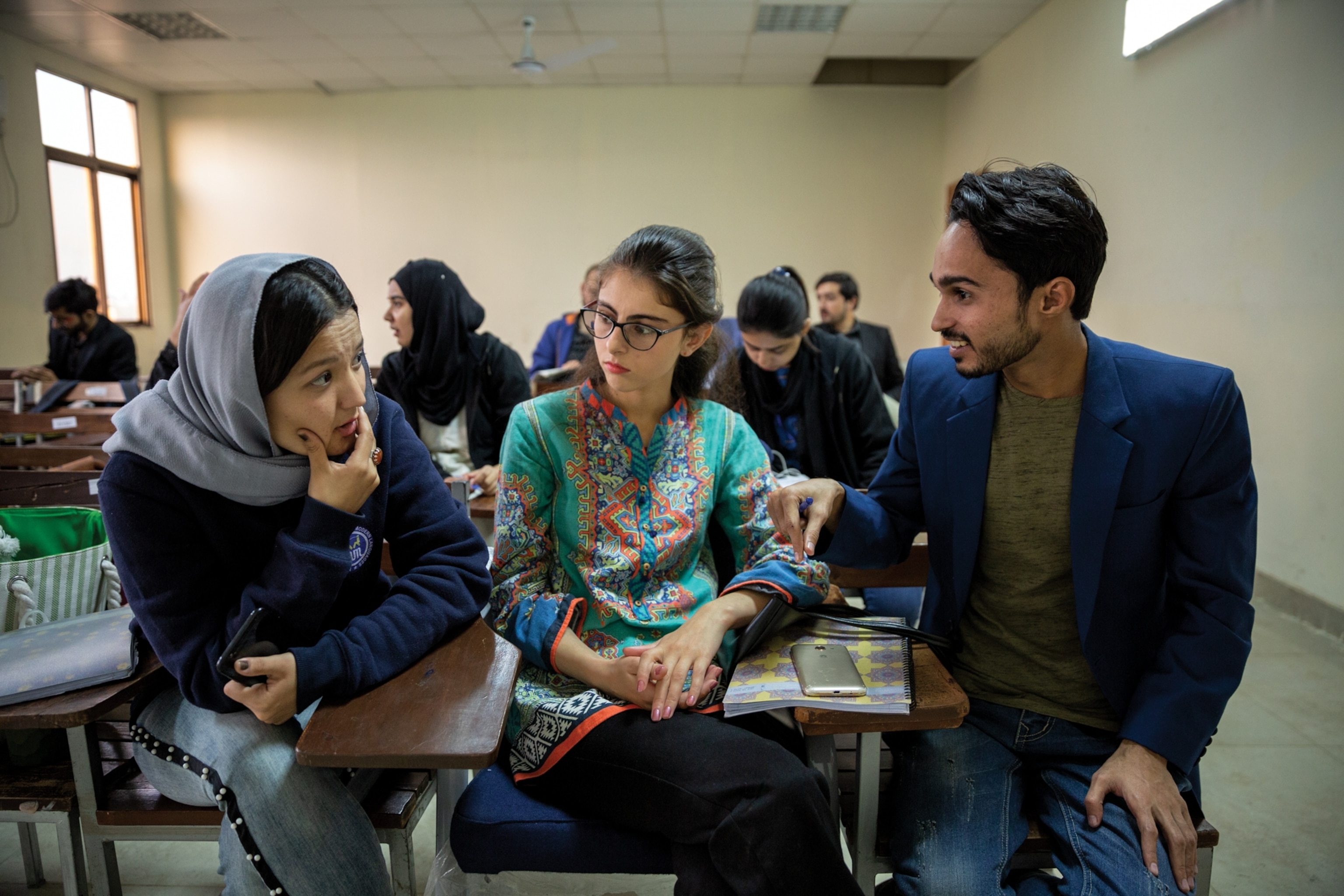 three people sitting next to one another having a conversation