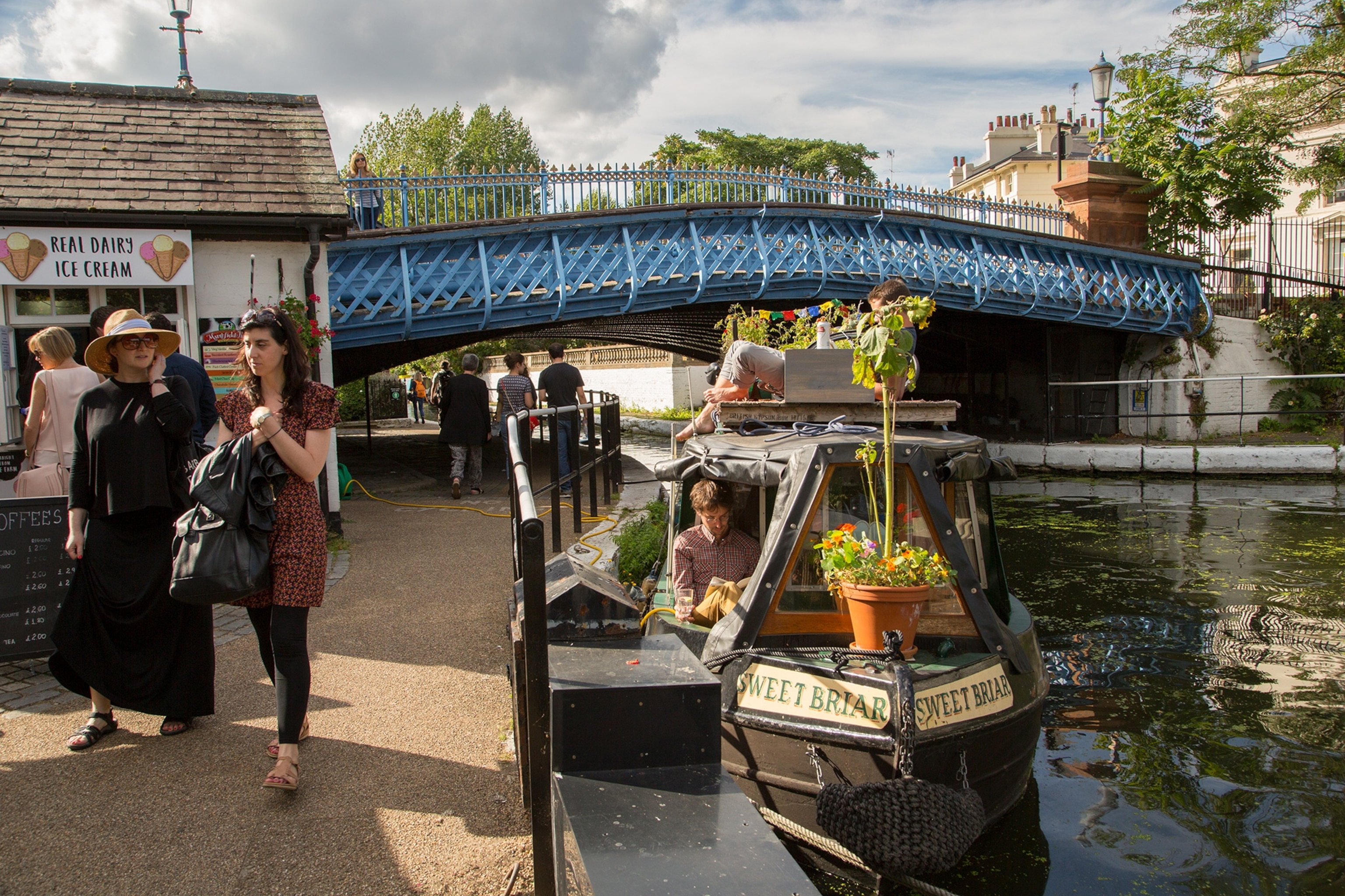 People relax on one of the houseboats on the Grand Union Canal at Little Venice, London.