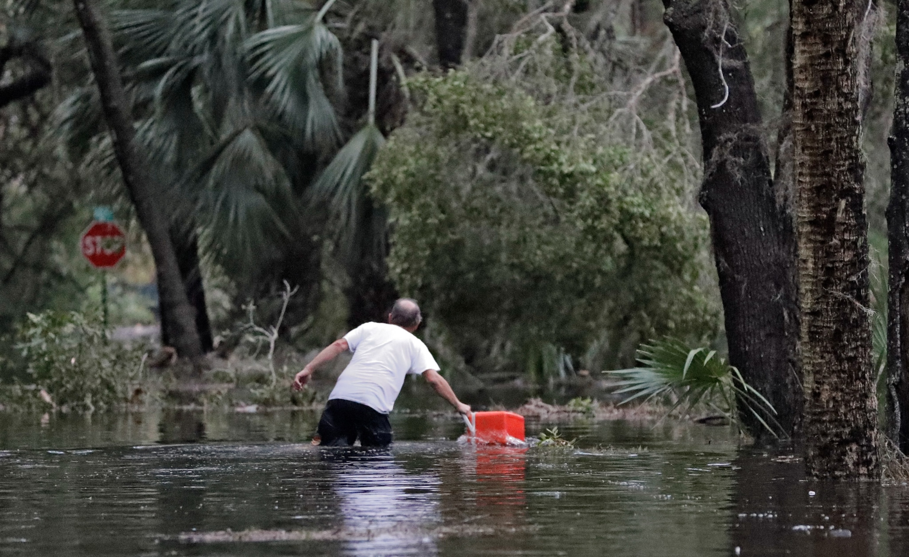 a resident pulling a cooler after Hurricane Michael