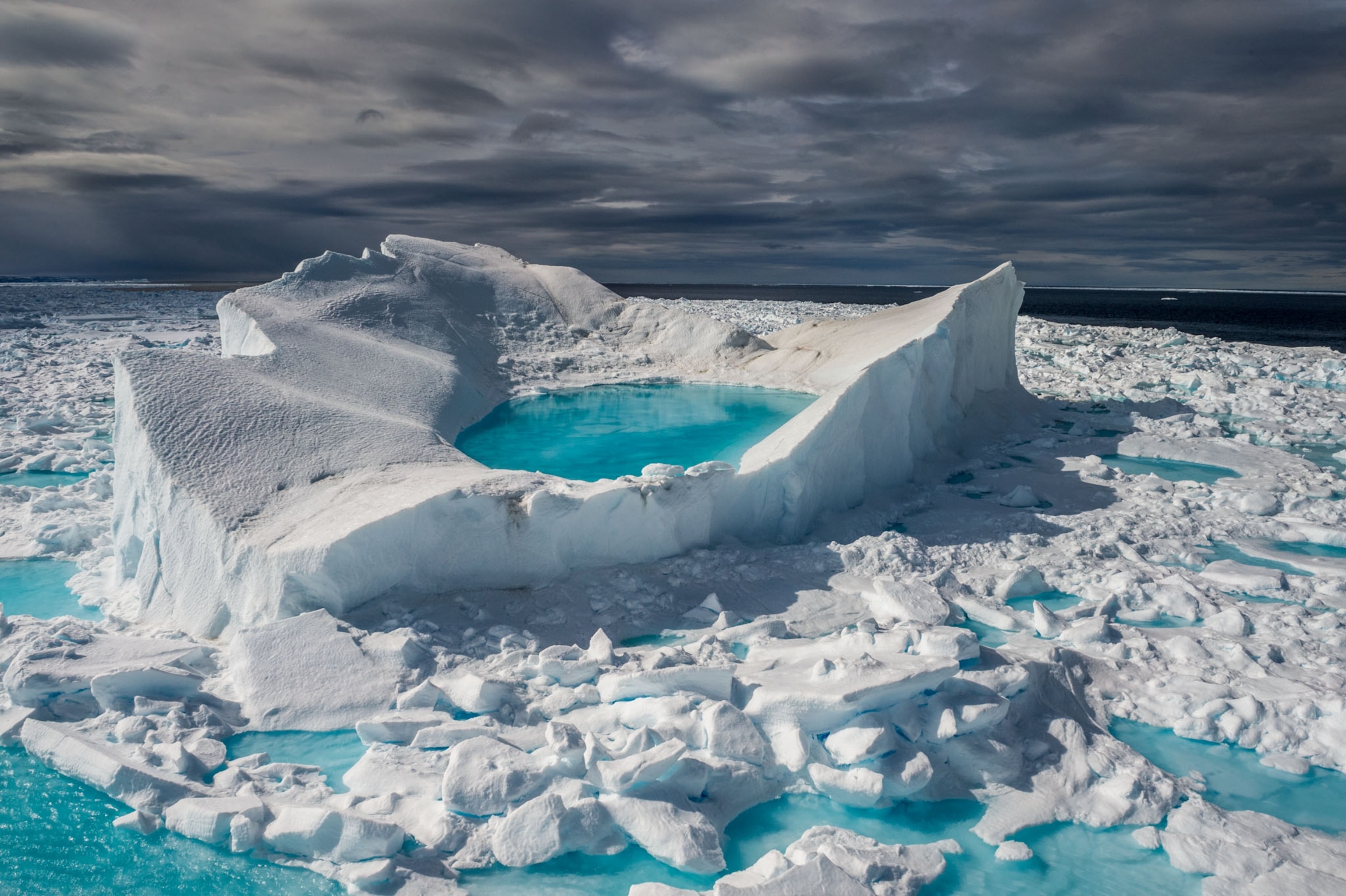 snow and ice float in a sea of turquoise, a natural pool is formed by the melting snow