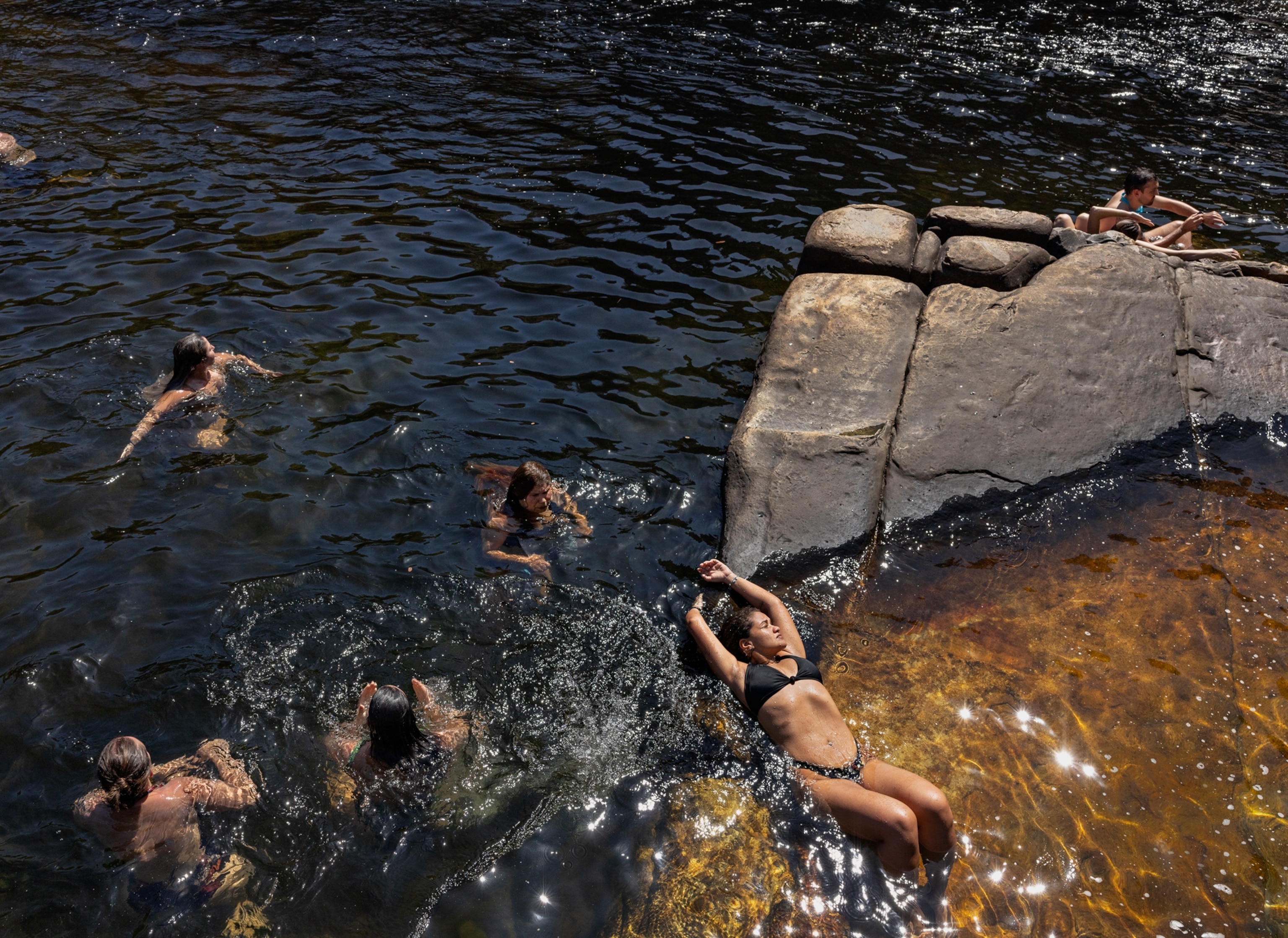 A photograph of people swimming and laying in the sun at Chapada dos Veadeiros National Park