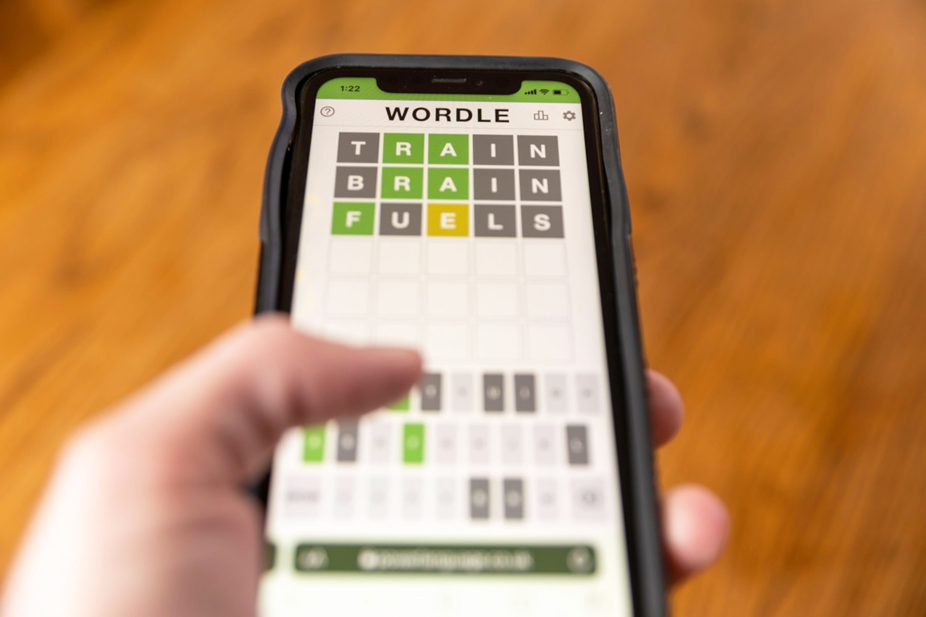 Brandon, MS - February 8, 2022: Hands playing Wordle game on phone.