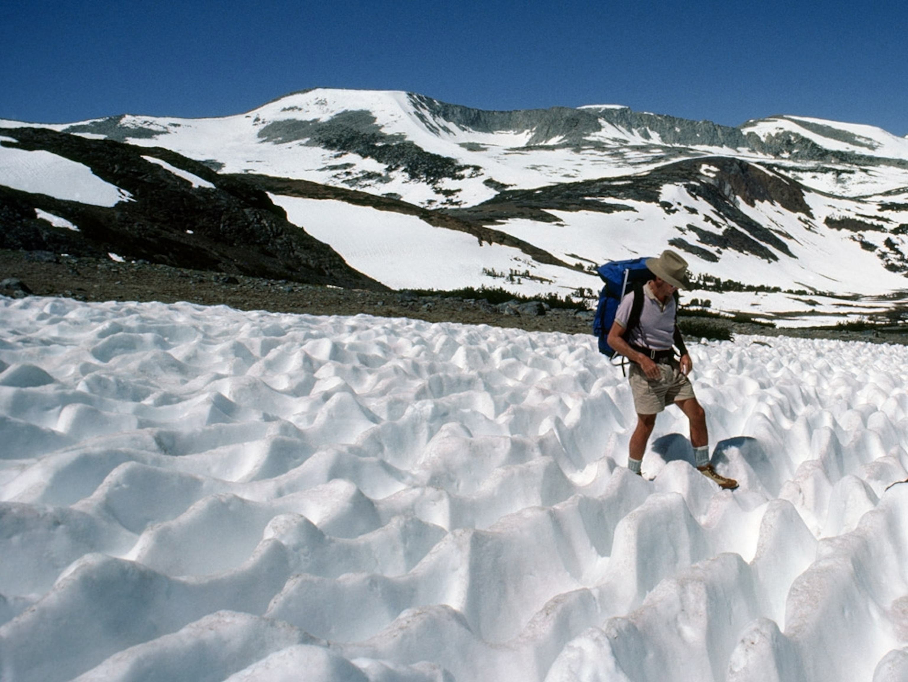 Two mountaineers trek across a snowy terrain