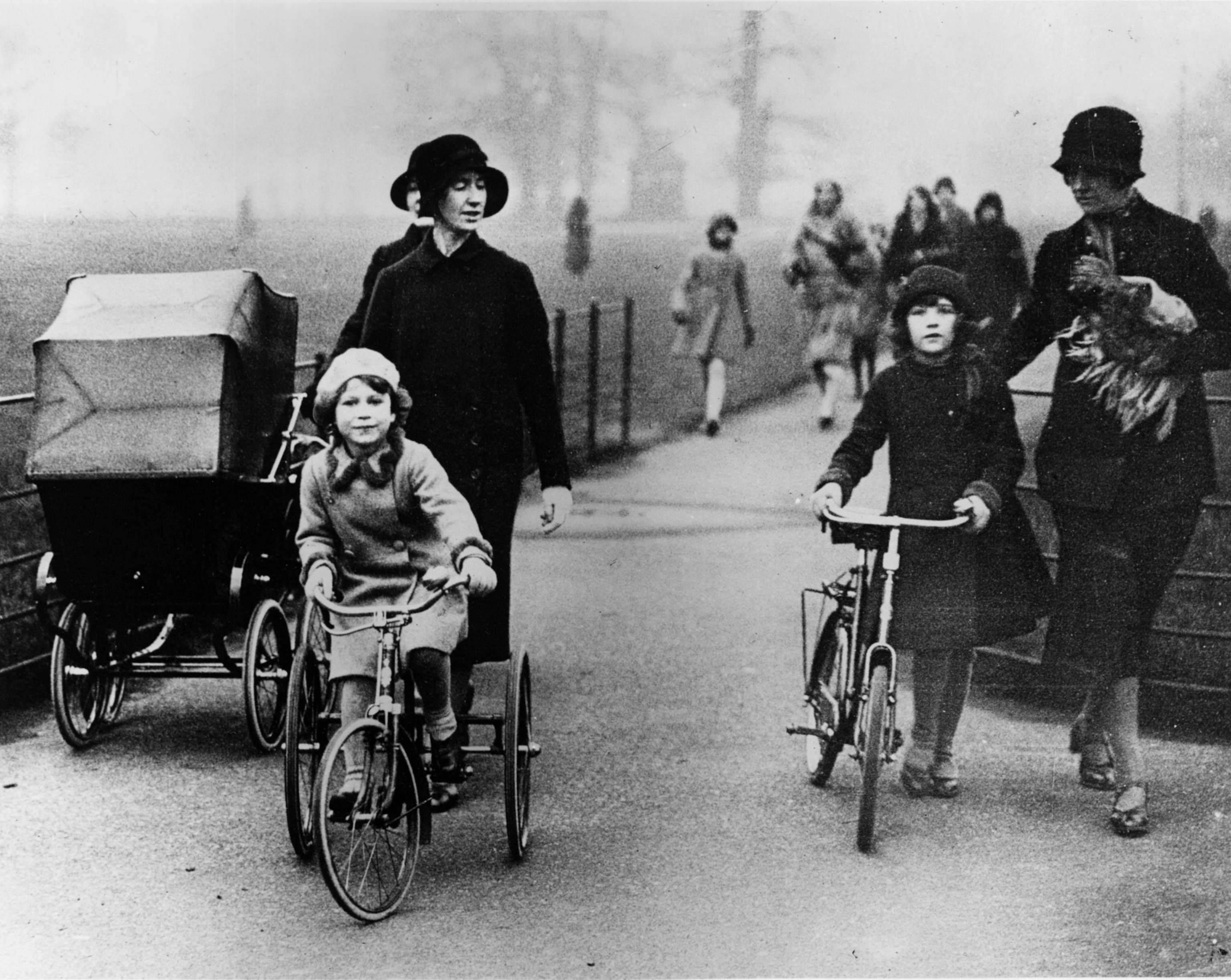 Princess Elizabeth riding her tricycle in the park