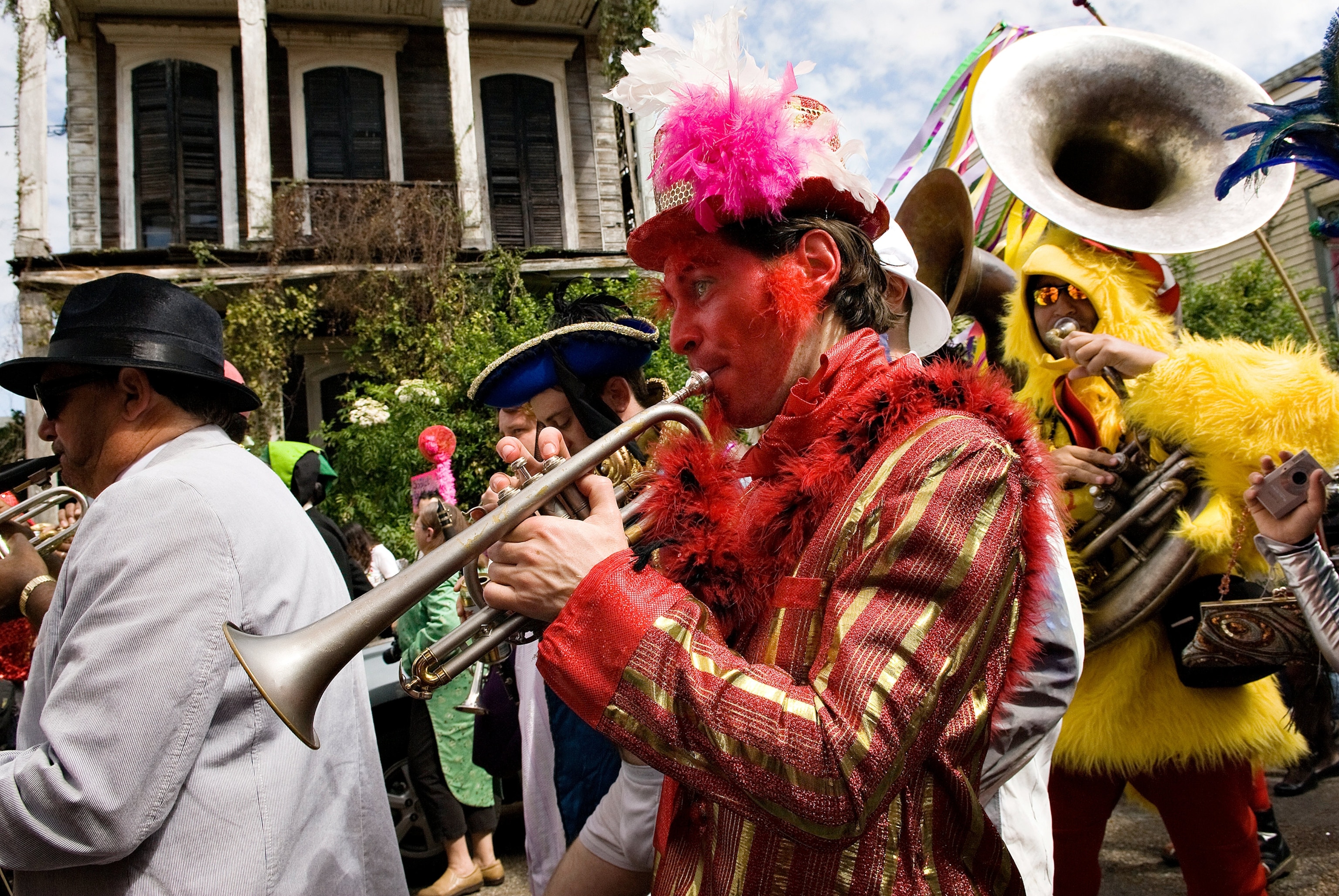 man dressed as a devil plays trumpet in the St. Anne Krewe