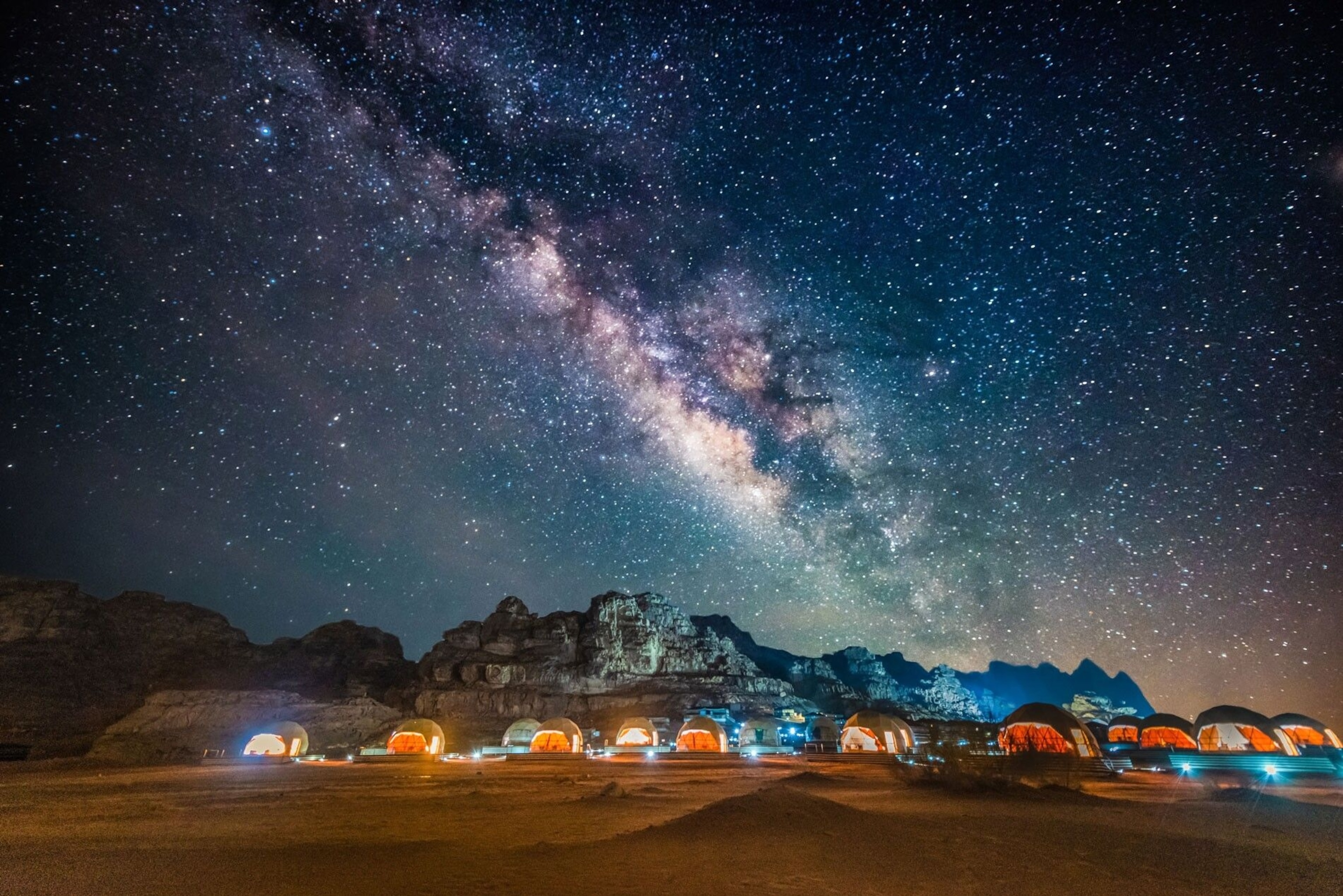 A field of tents below a sky full of stars.