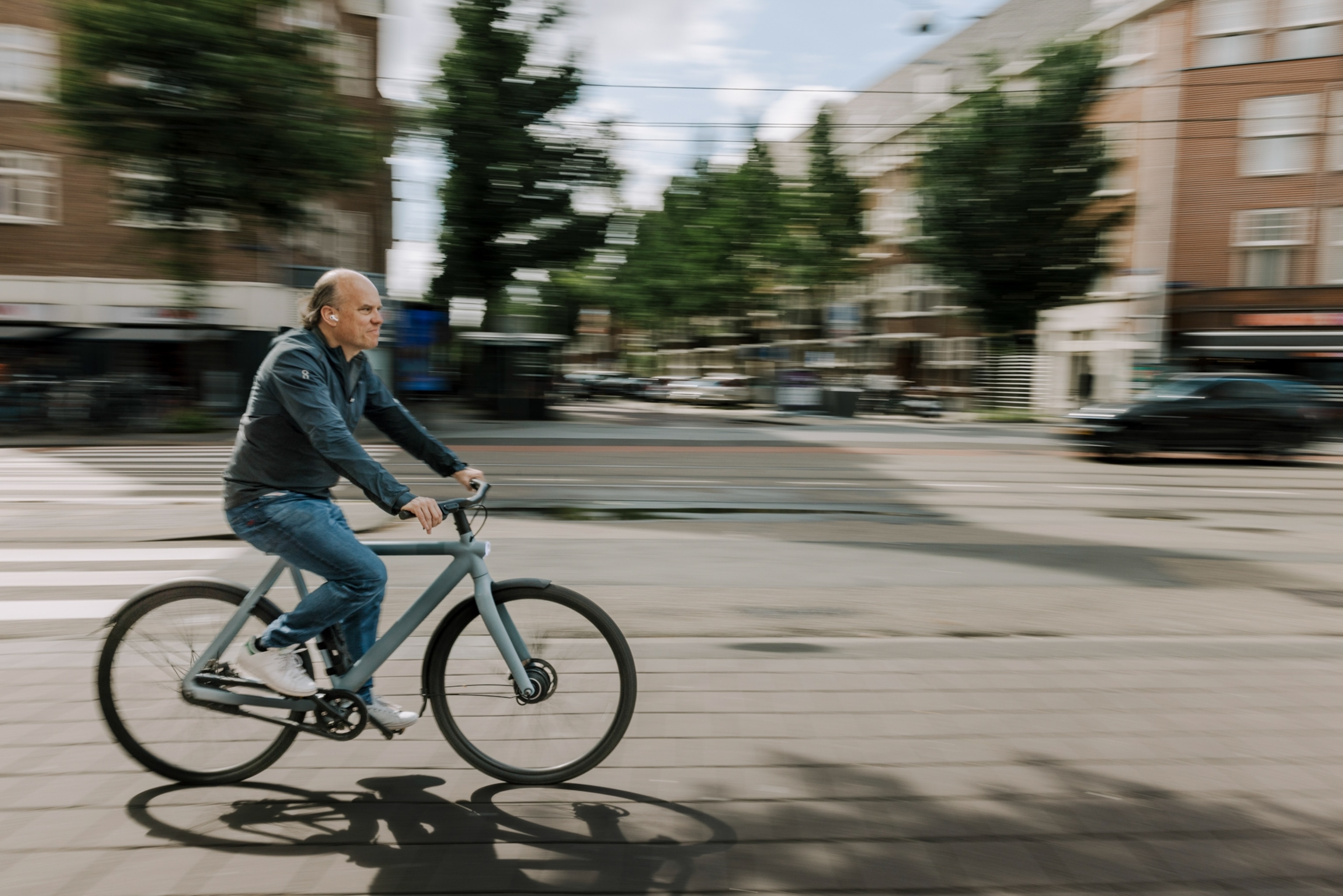 A man riding an electronic-bike on a road in Amsterdam.