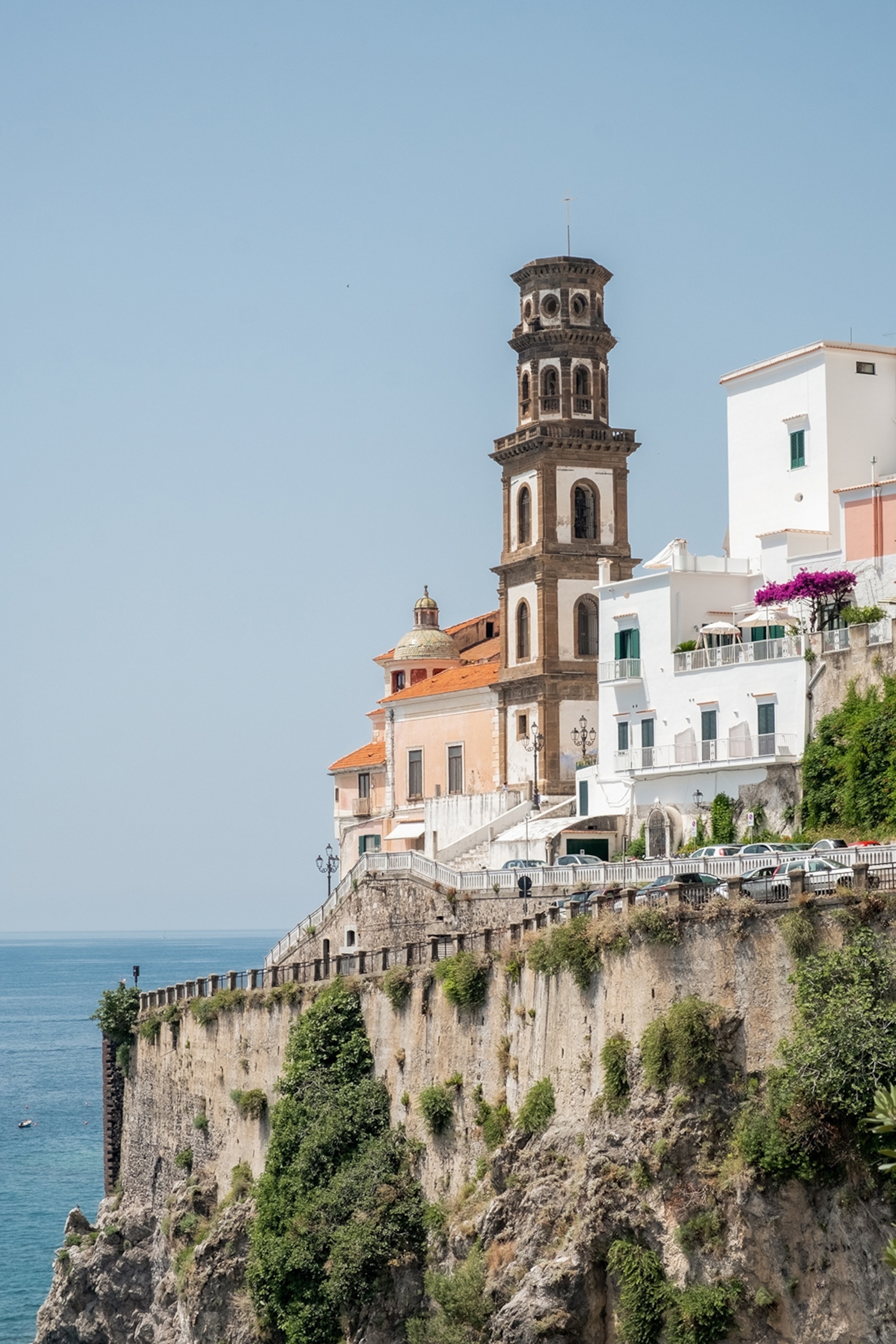 Buildings perched on a cliffside overlooking the sea