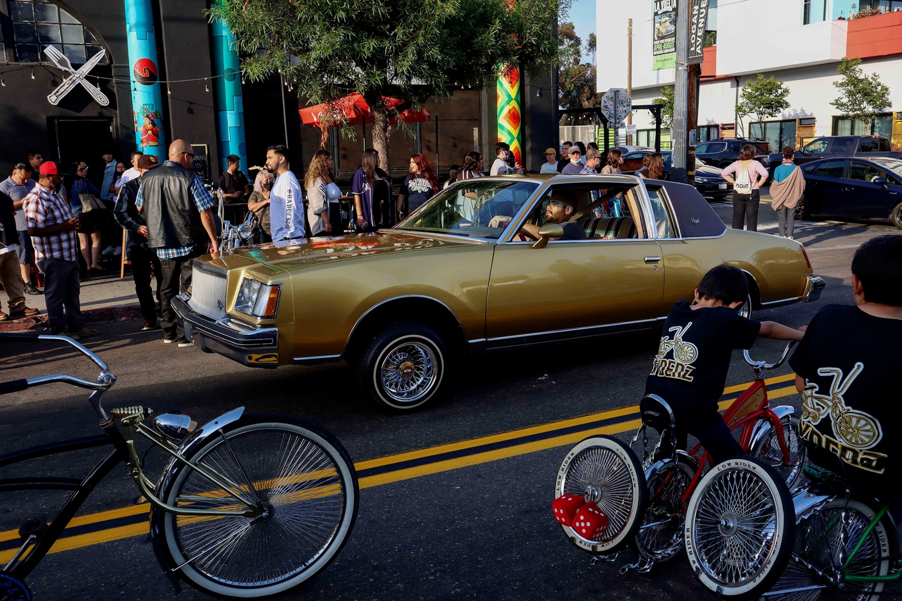 Lowrider enthusiasts cruise down Logan Avenue.