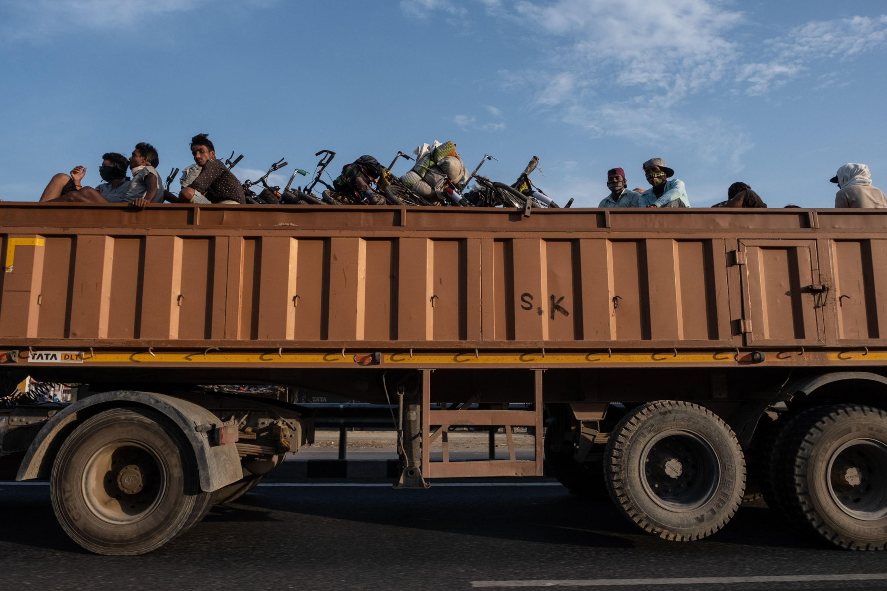 the exterior of a truck, with many heads above the edges of the truck railing