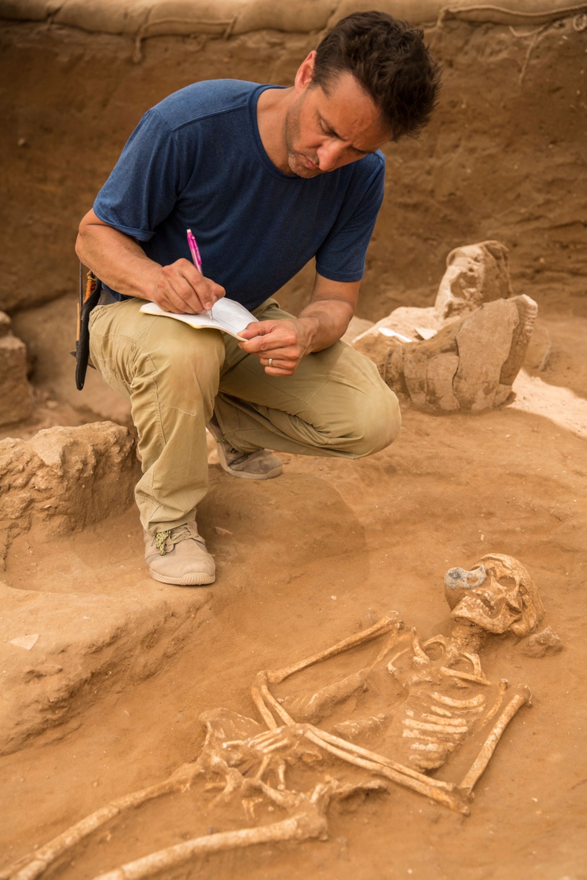 Adam Aja documenting Philistine skeleton in Ashkelon, Israel