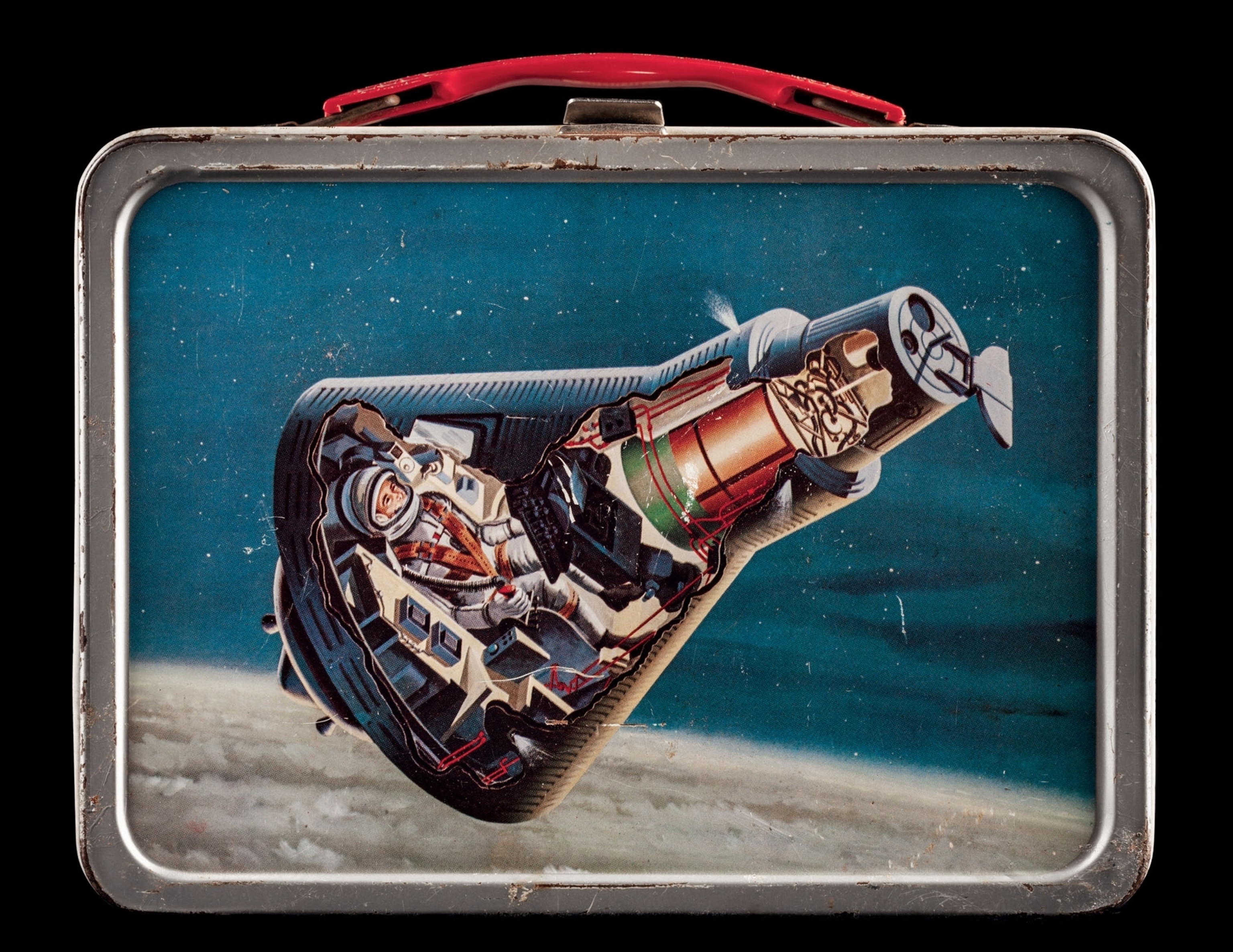 a lunchbox with a astronaut in a space capsule on the front