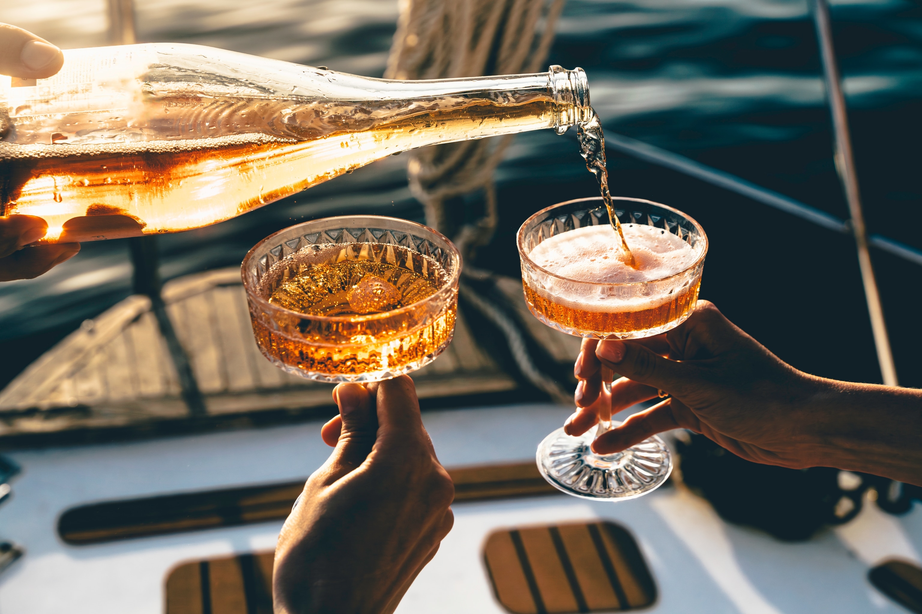 Sparkling rosé wine being poured on deck