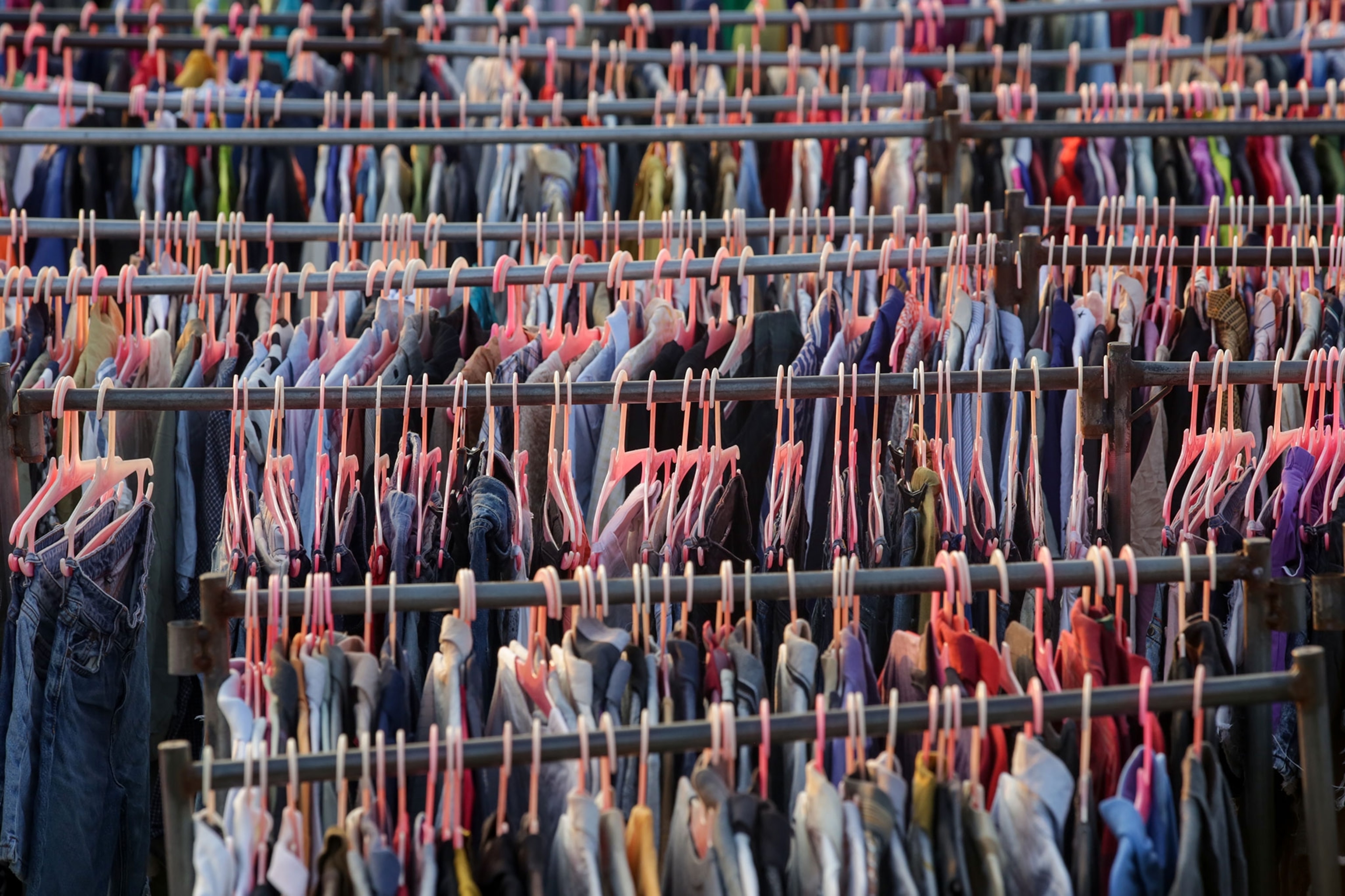 Close up of racks of clothing with pink hangers
